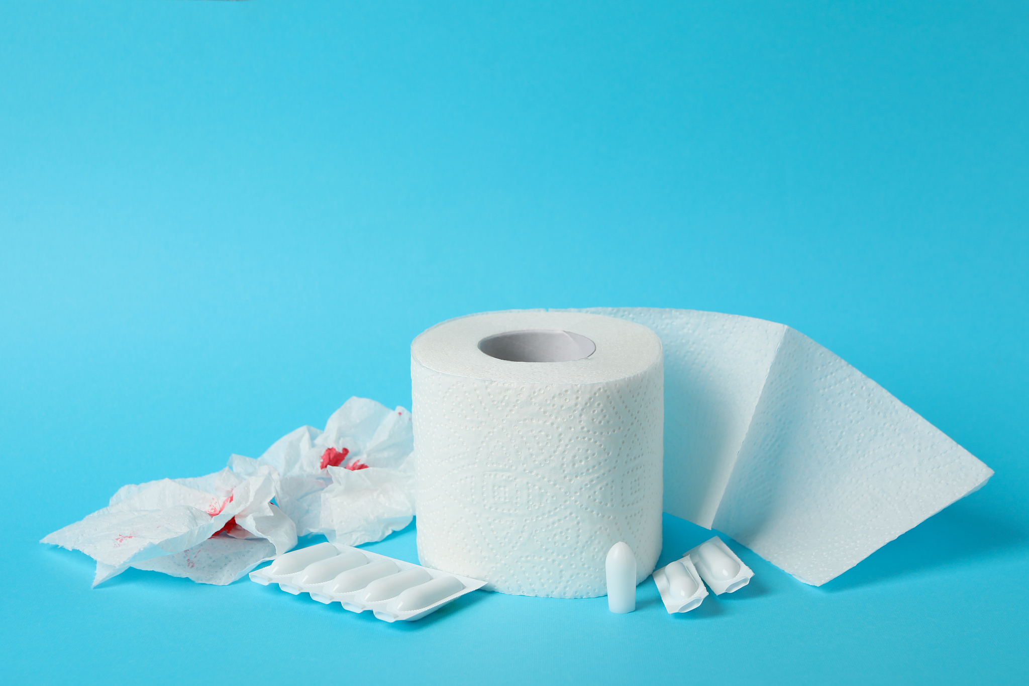 toilet paper, candles and paper with blood on blue background, c