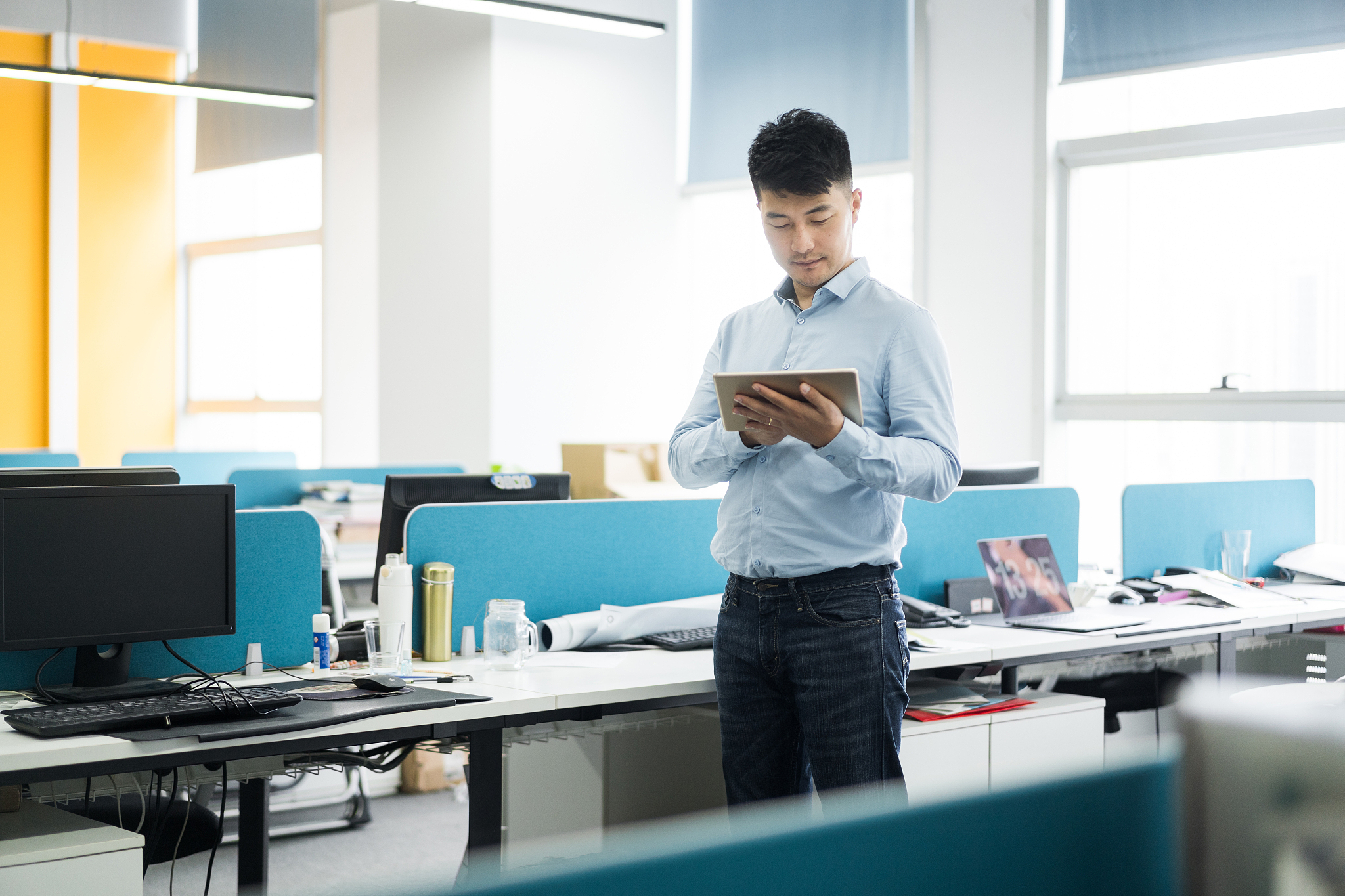 young man uses digital tablet in modern office