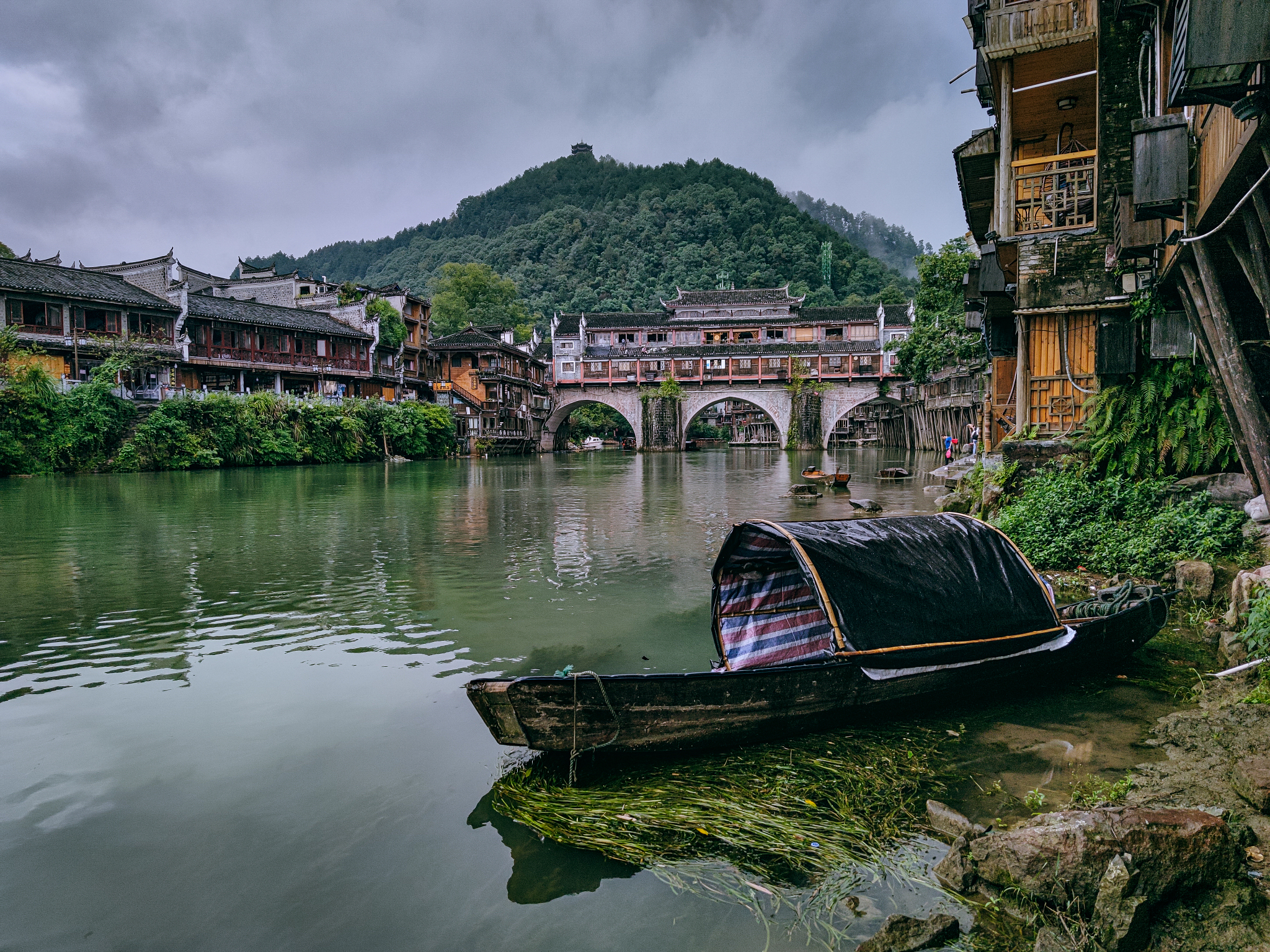 请改变语言并扩写写以下内容：把《边城》通篇读下来我读出了沈先生会湘西风情的钟爱读出了当地的人们纯朴赤诚读出了故事淡淡的忧伤。在文中先生用幽淡的笔墨向人们呈现出湿润透明的湘西美景其中那座碧溪岨的白塔给我留下了最为深刻的印象。那座立在半山腰的白塔就像是一个沉默的精灵远远地眺望着老船夫和翠翠的家默默地给予他们祝福。它就像是老船夫和翠翠心灵的港湾。每当他们有心事无处诉说他们总会出神地遥遥望着白塔让被现实束