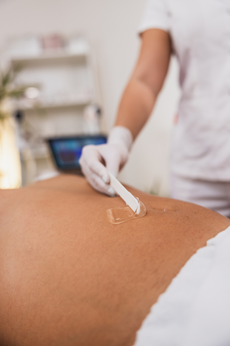 女性双手在男性腹部涂抹凝胶,准备接受治疗