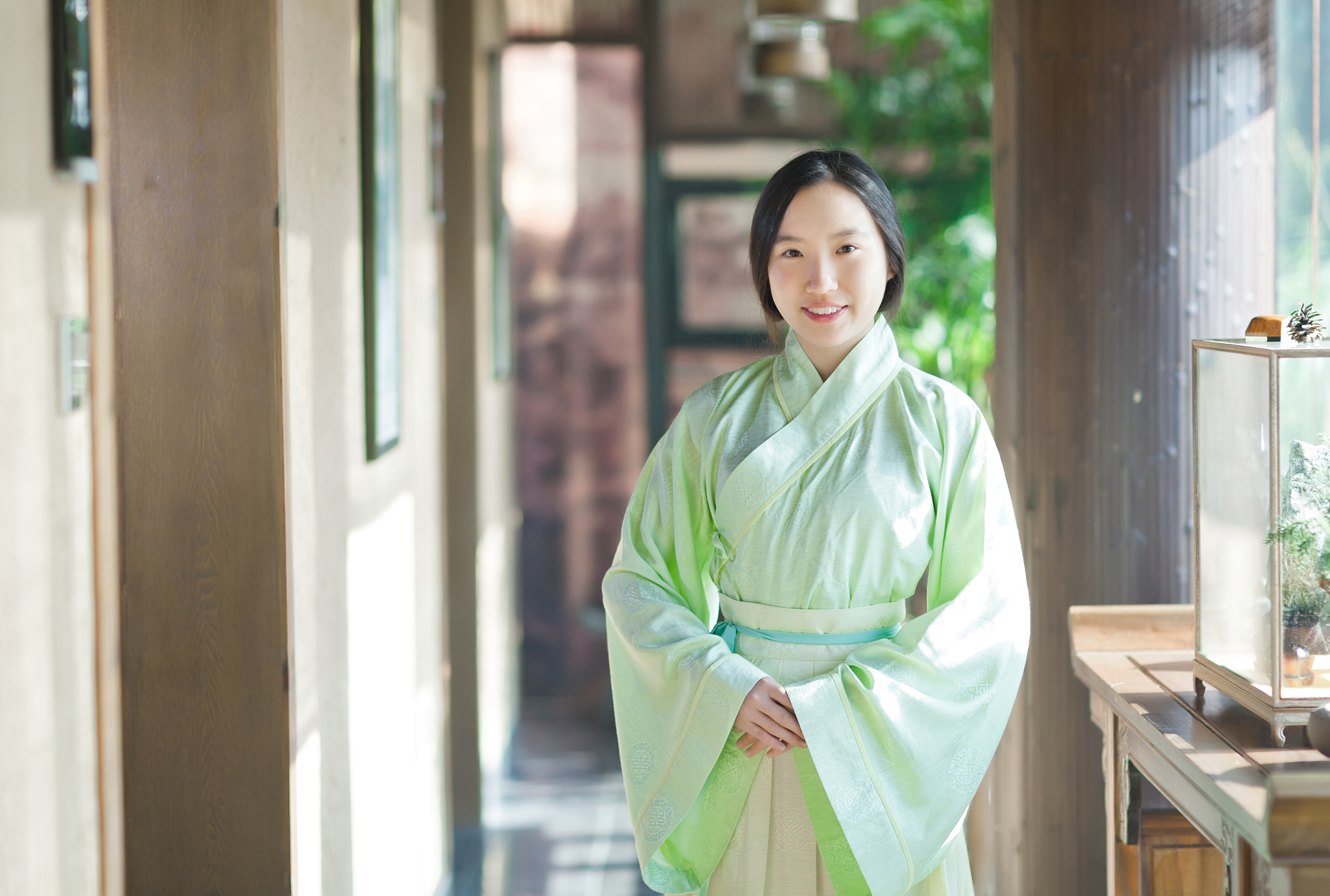 用英文翻译下面的话 在一部由宫崎骏执导的复古动漫中有一个穿着红色汉服的美丽女孩。她有着黑色头发头上戴着一朵娇艳欲滴的花朵使她显得更加婀娜多姿。她的额头上还戴着一件精美的头饰闪闪发光犹如星辰落入凡间。此外她的脖子上还戴着一串闪烁着光芒的项链与她的美貌相得益彰