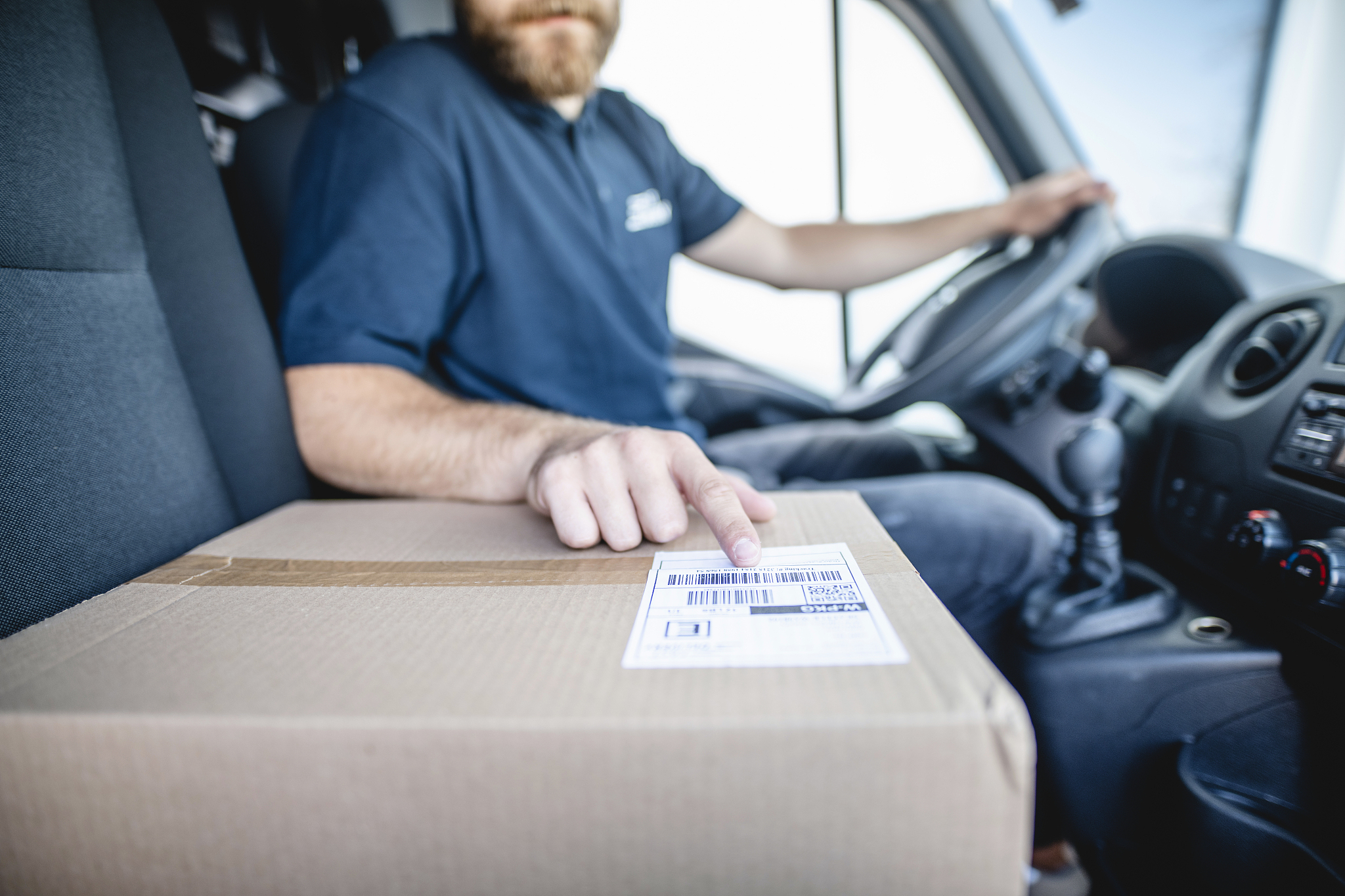 delivery driver pointing to bar code on package