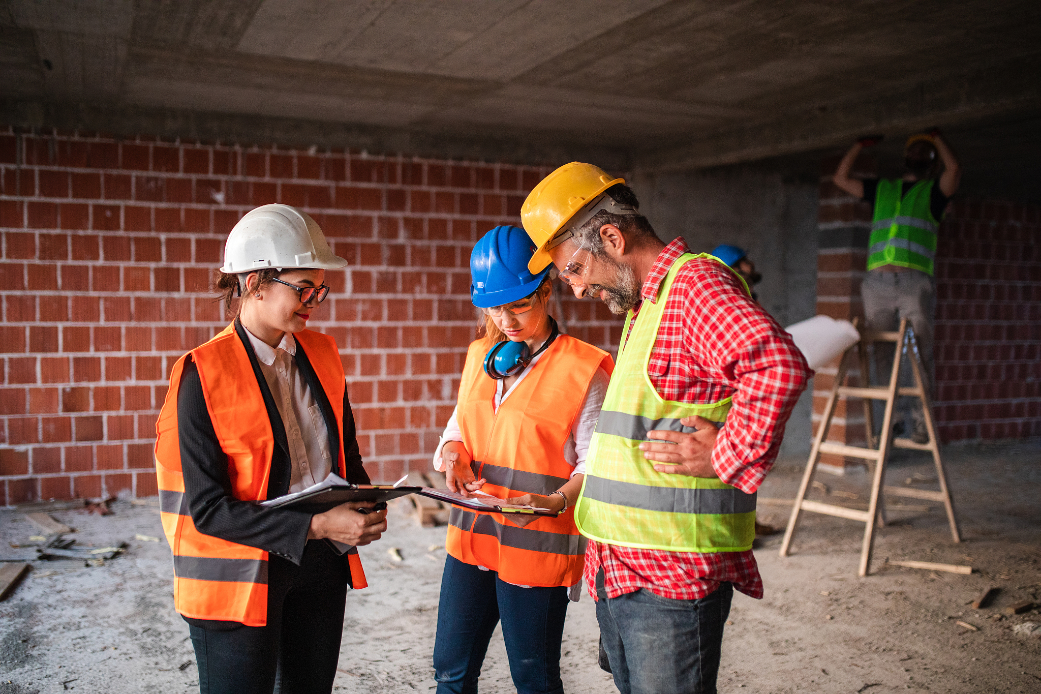 architects writing on clipboard at construction site