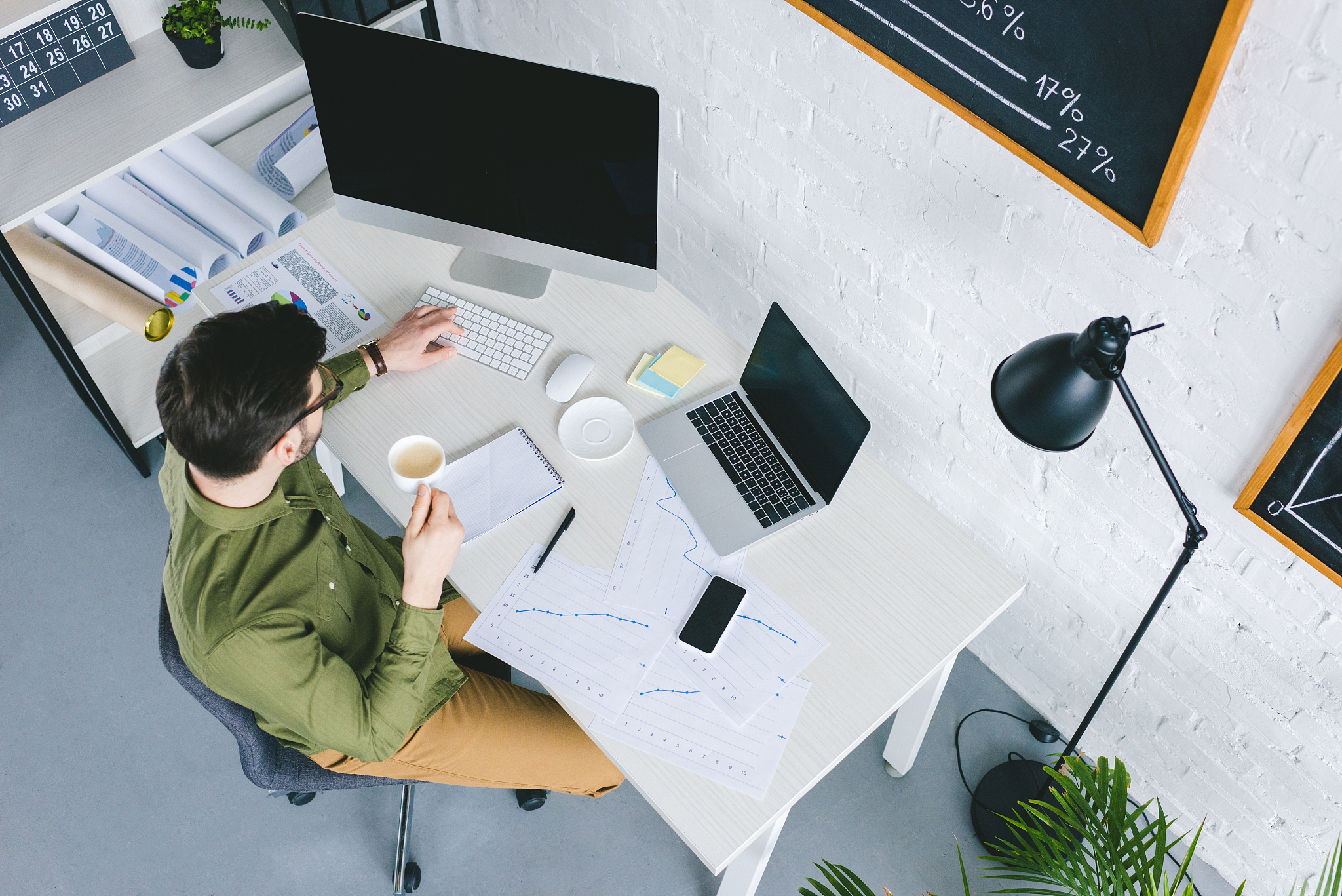 young businessman working by computer and drinking coffee at hom
