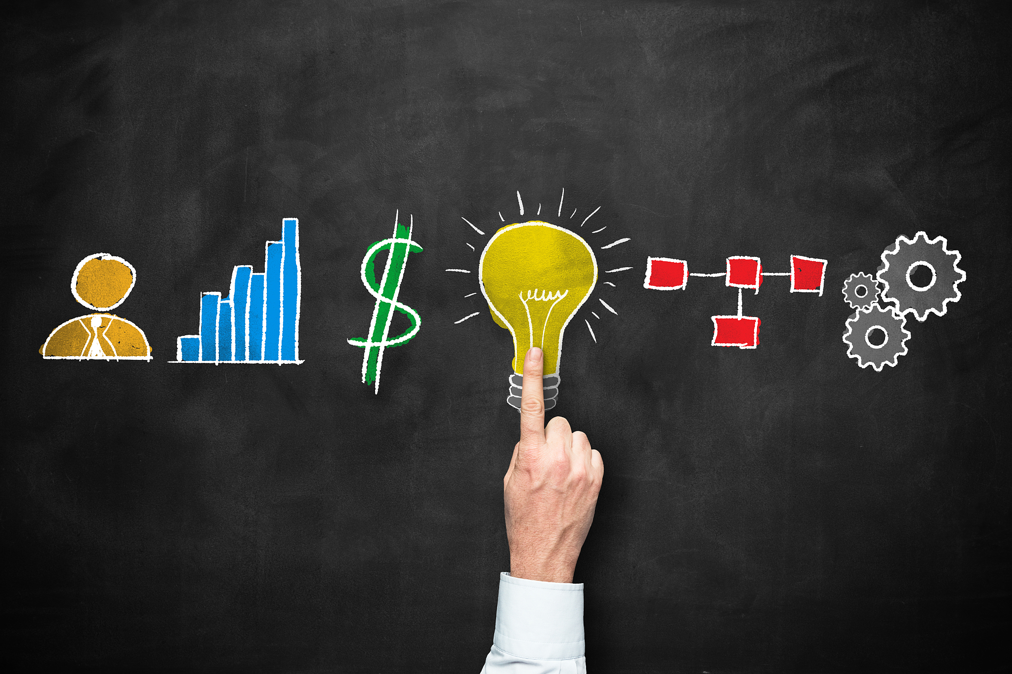 marketing icons on blackboard with human hand