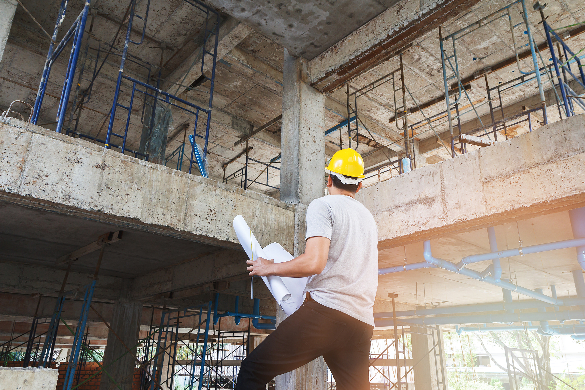 engineer with blueprint in building construction site