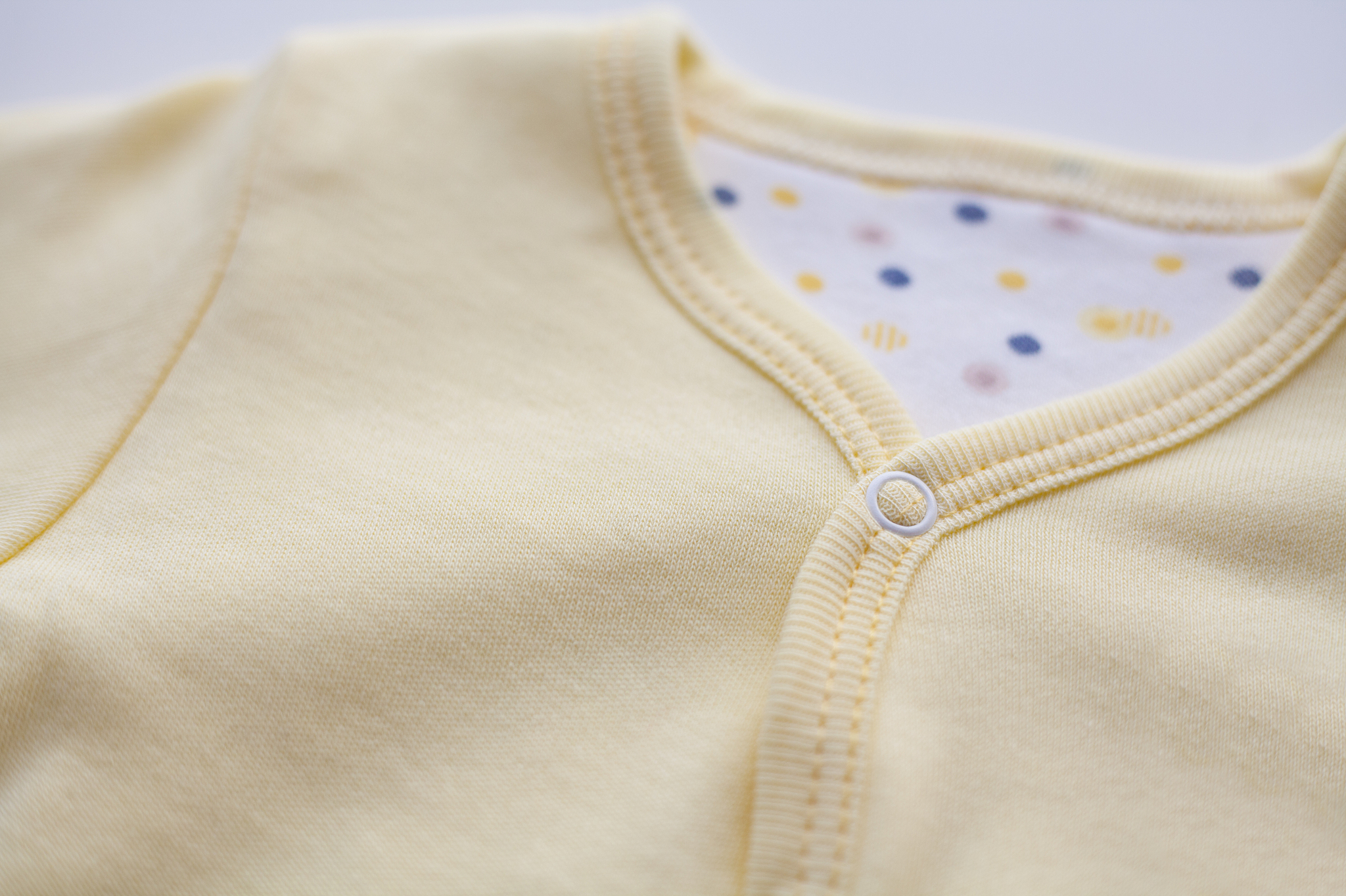 帮我撰写一篇居家童装内衣的文案以描述服饰具体细节为主题服装类型：纯白系列亲子居家内衣、白色打底黄色花瓣为亮点缀满整体的长袖内衣服饰、清新且活力十足的纯棉内衣系列