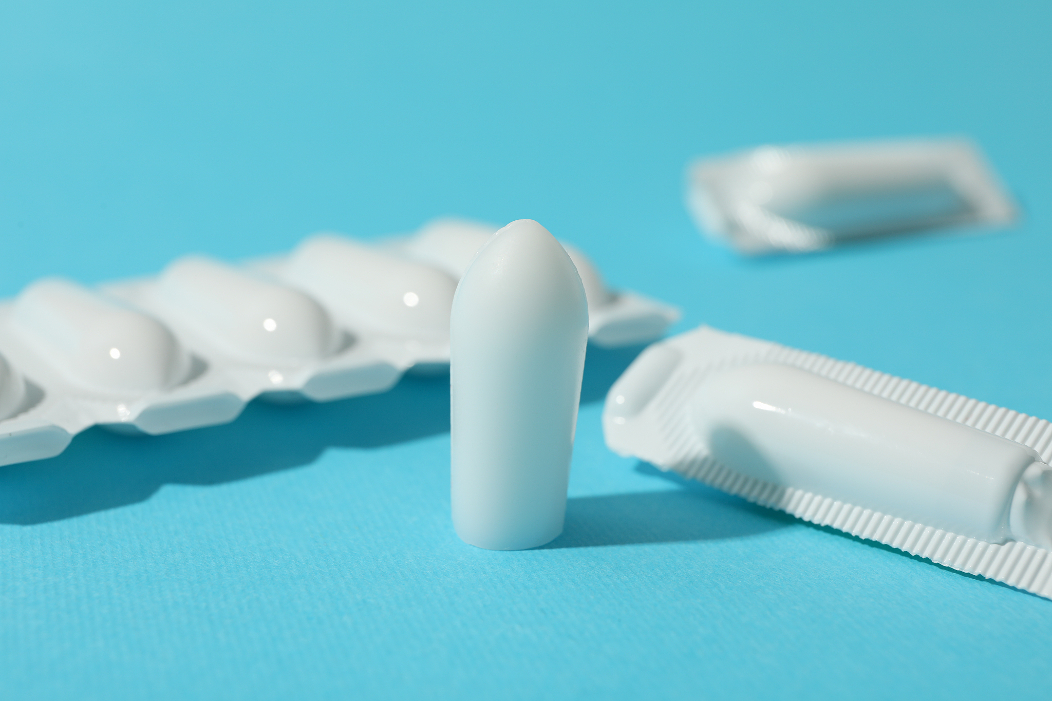 anal or vaginal candles on blue background, close up