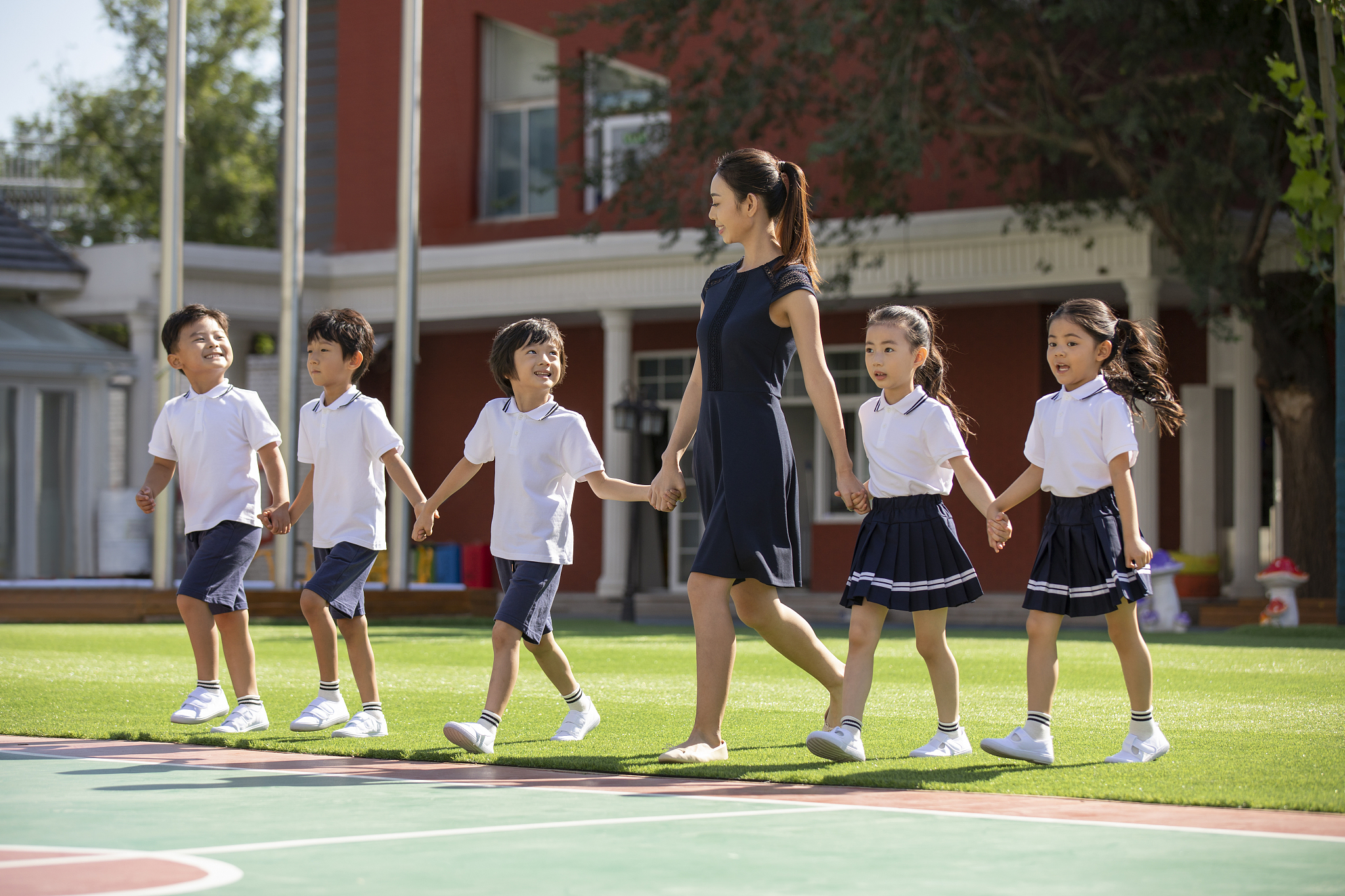 幼儿园老师和学生在操场上