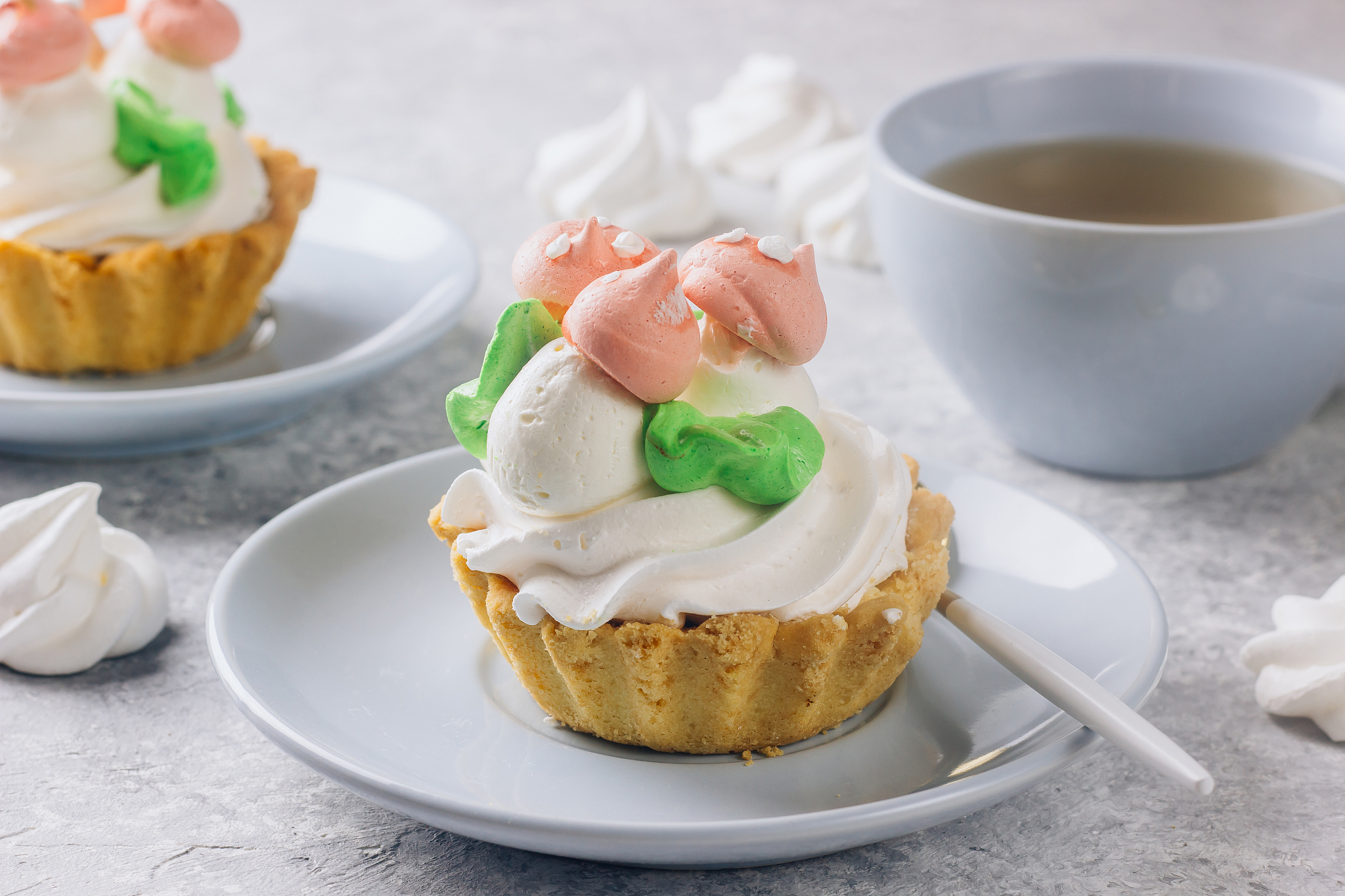 delicious funny tartlets with meringue for kids on a light blue 