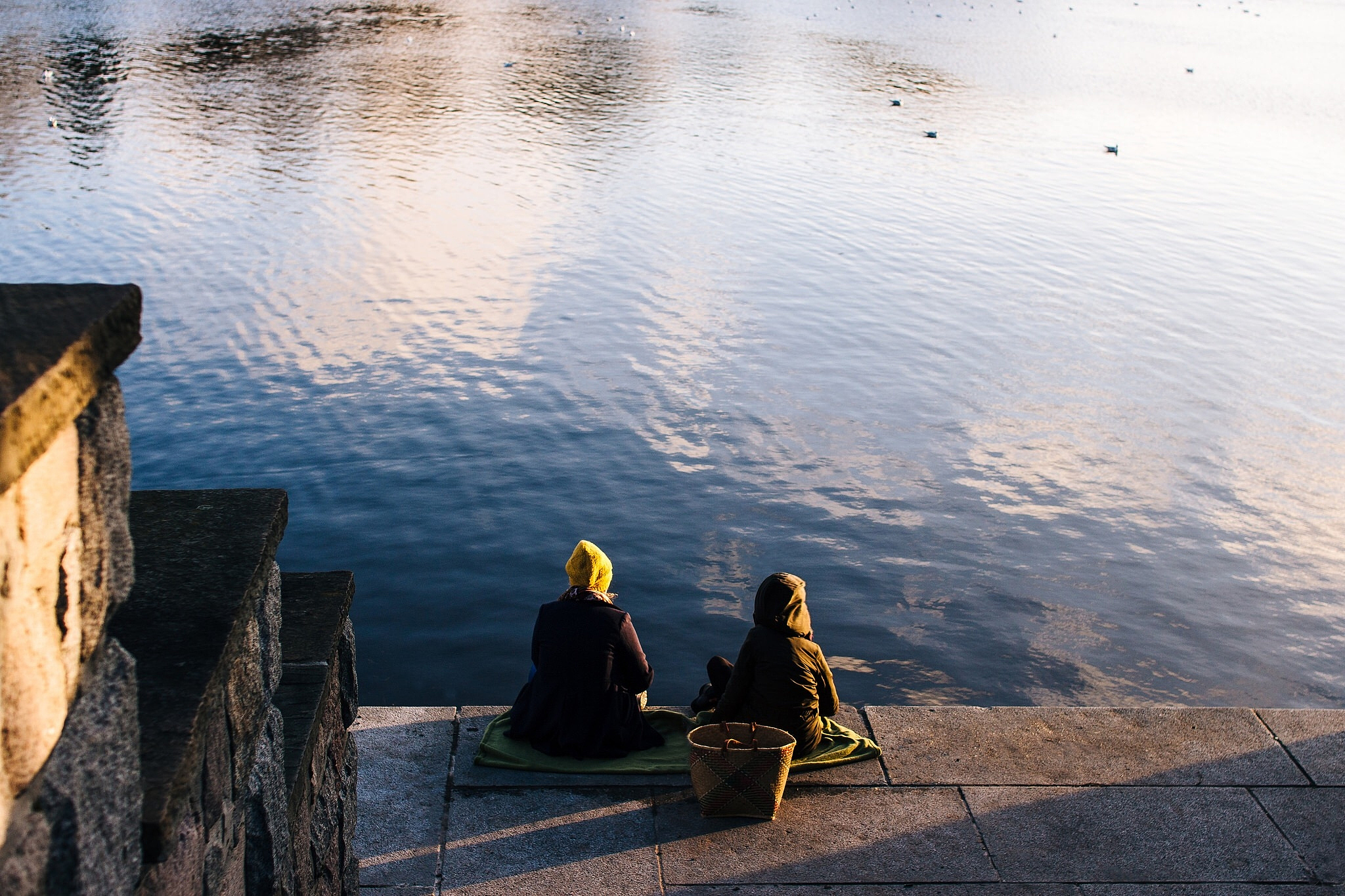 women sitting by river