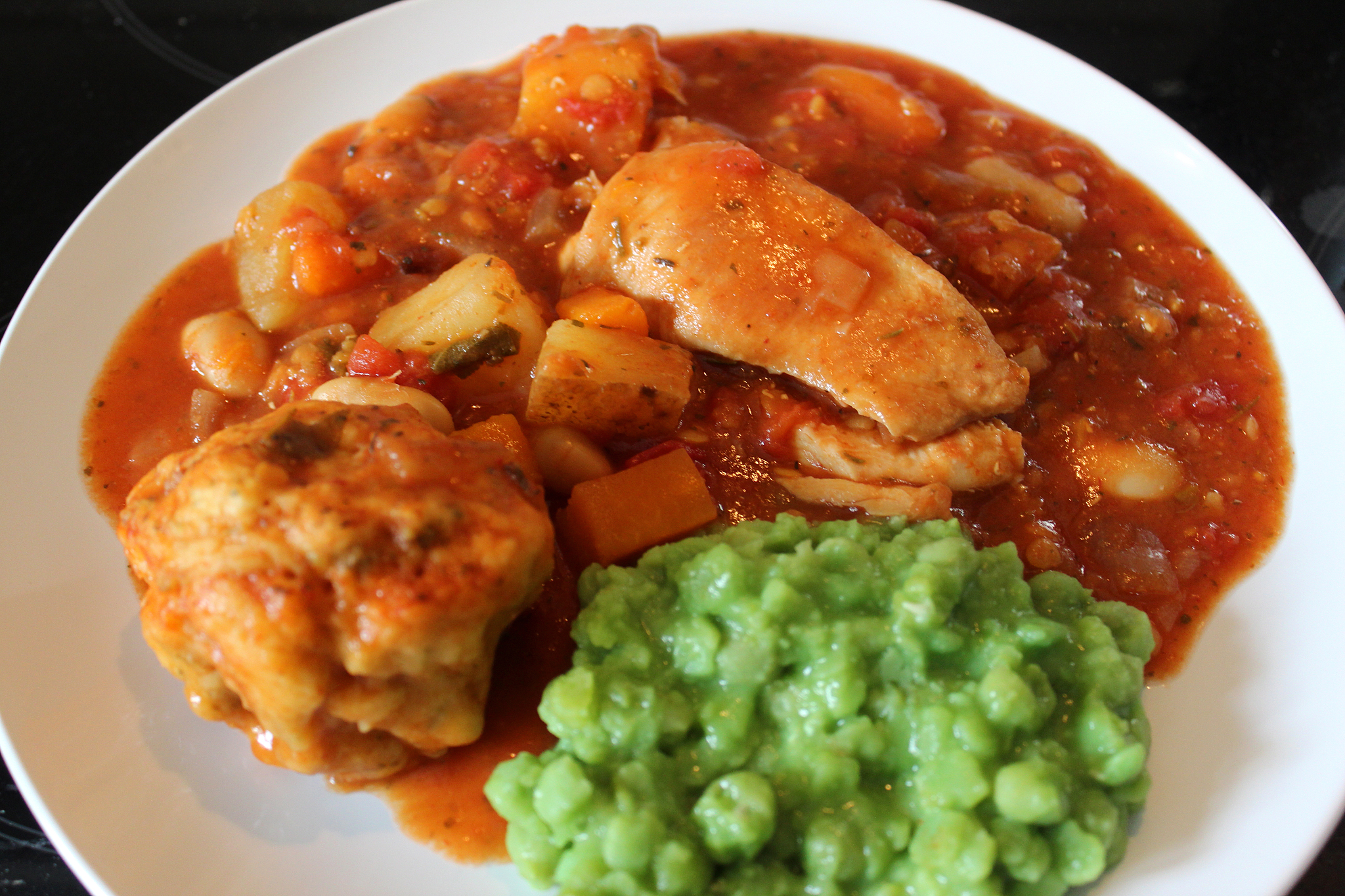 image of chicken casserole meal with mushy peas, vegetables, gra