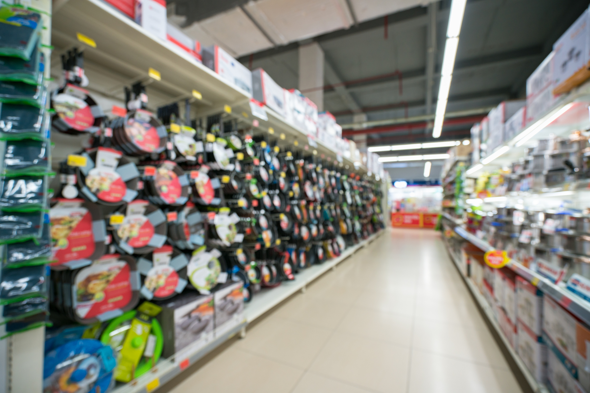 supermarket blurred background with colorful shelves and unrecog