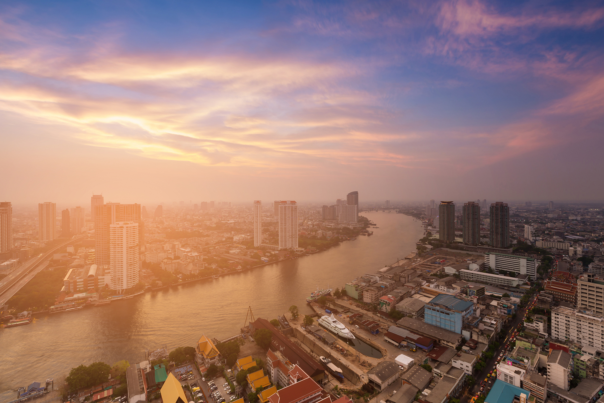 river curved over city downtown skyline with sunset background