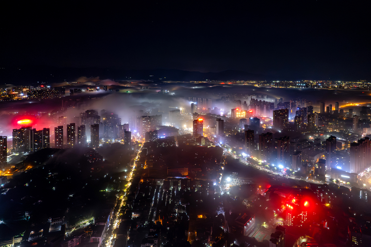夜间雾中城市建筑与灯光的航拍视角