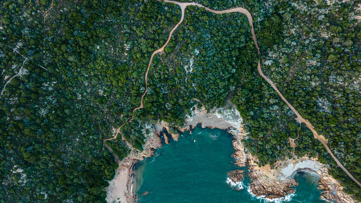 帮我降重句子意思不变海口市地形略呈长心形地势平缓。海南岛最长的河流——南渡江从海口市中部穿过。南渡江东部自南向北略有倾斜南渡江西部自北向南倾斜；西北部和东南部较高中部南渡江沿岸低平北部多为沿海小平原。全市除石山镇境内的马鞍岭海拔2228米、旧州镇境内的旧州岭海拔1999米、甲子镇境内的日晒岭海拔171米、永兴镇境内的雷虎岭海拔1683米等38个山丘较高外绝大部分为海拔100米以下的台地和平原。