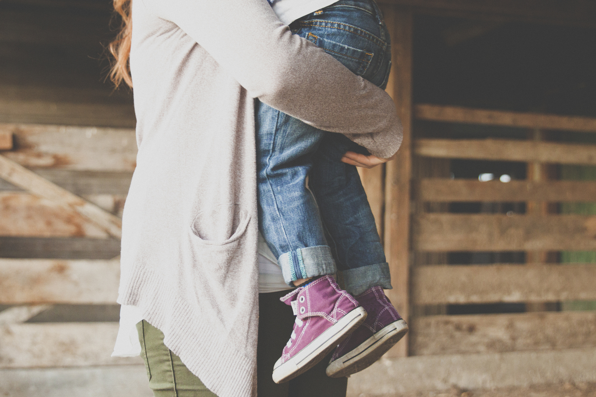a mother carrying her son after a long day.