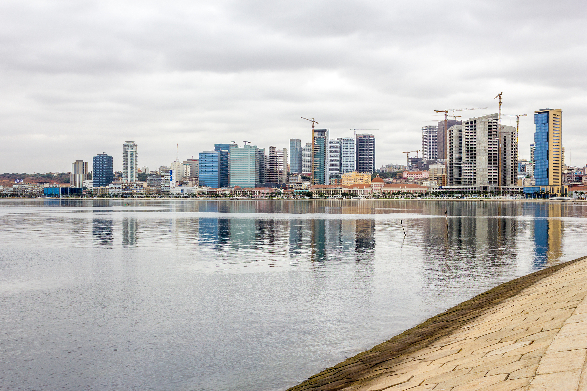 sea by cityscape against sky