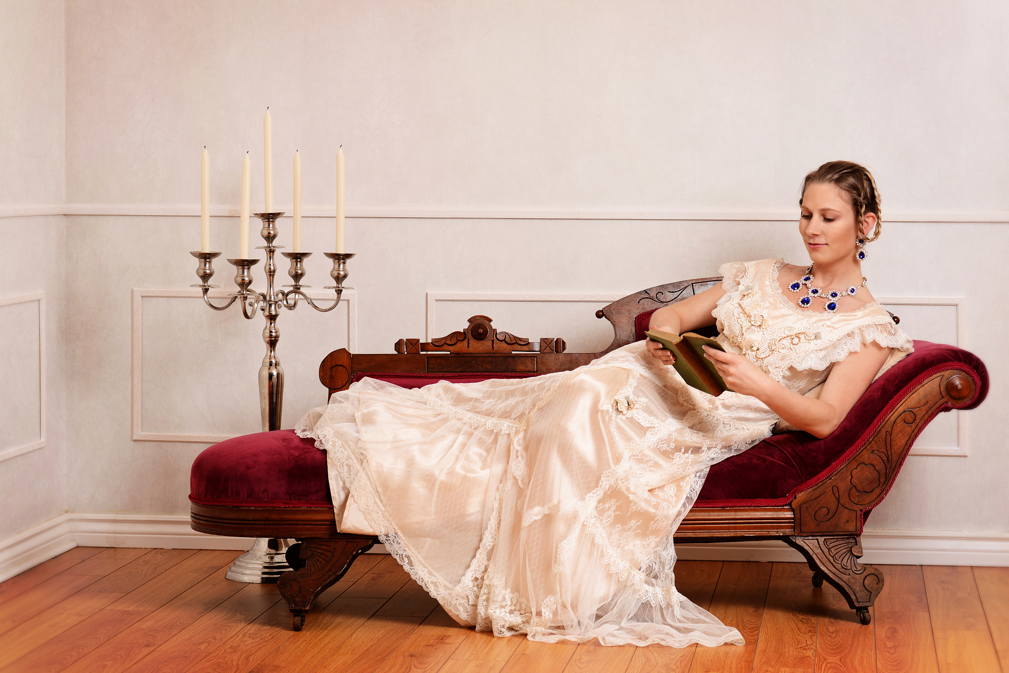 victorian woman reading book on fainting couch