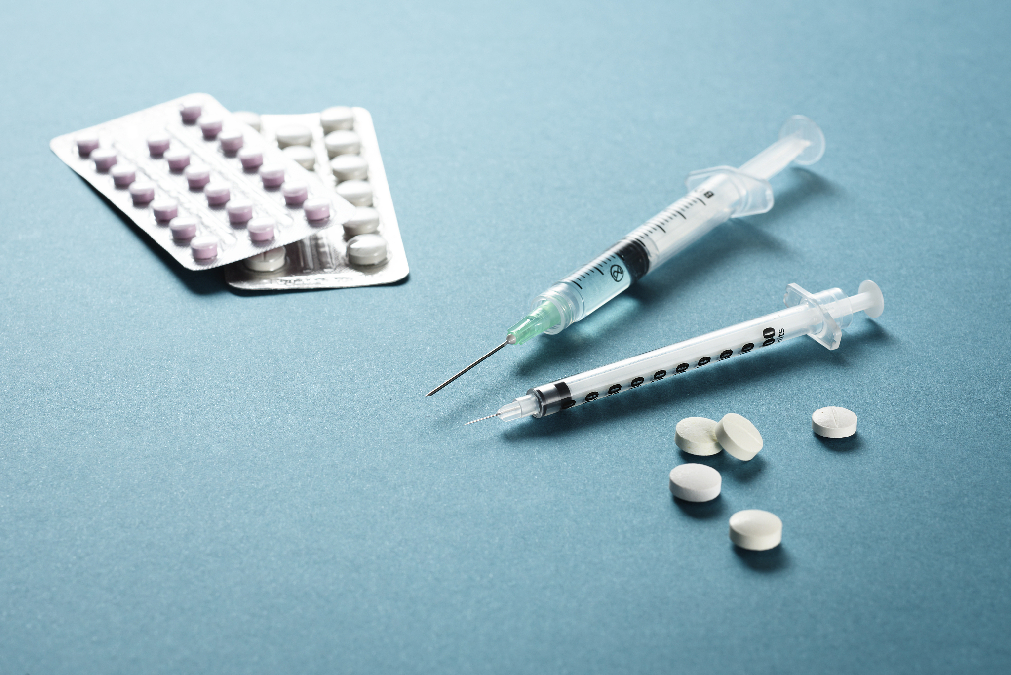 syringes with needles among tablets or medicine pills and medici