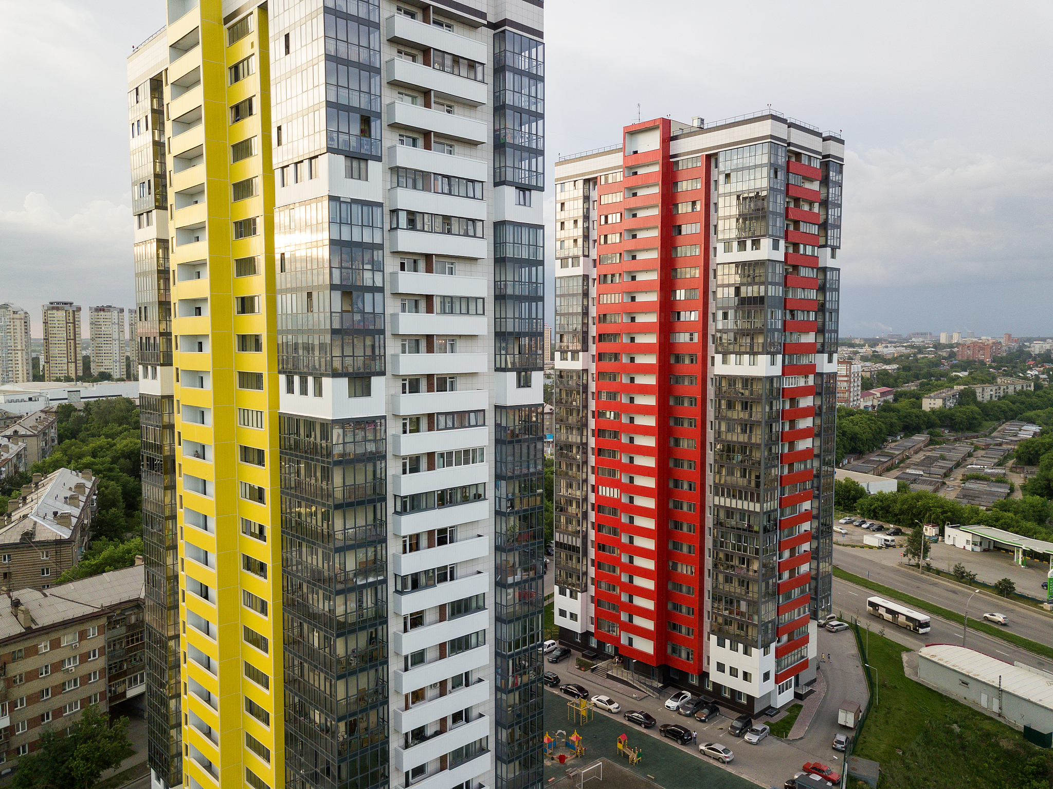 close-up aerial view of two tall skyscrapers of red and yellow c