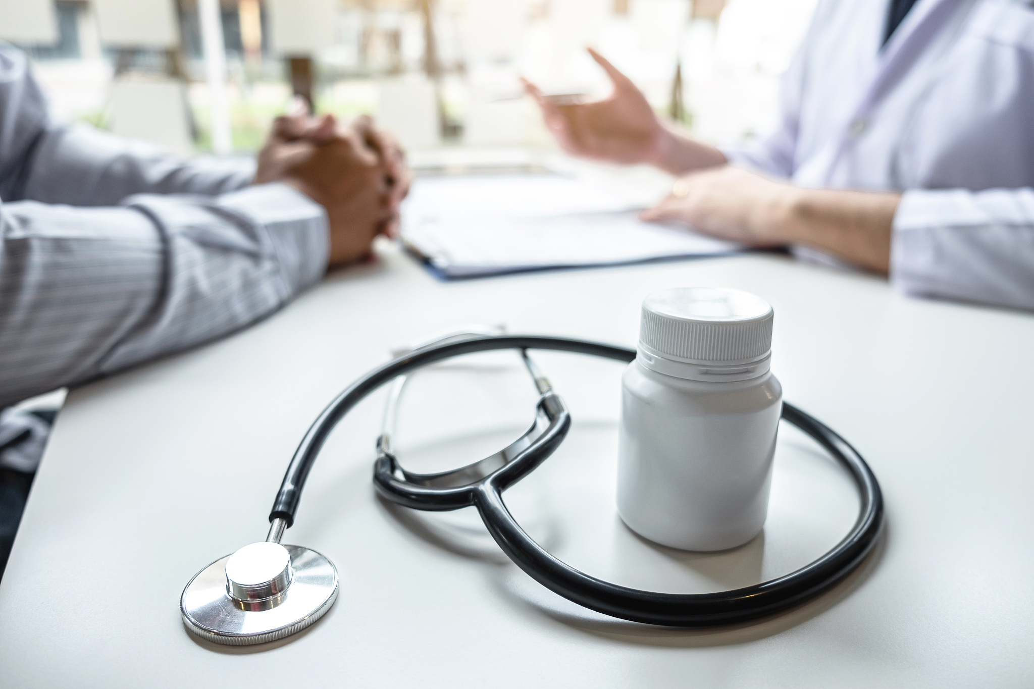 midsection of doctor and patient over table