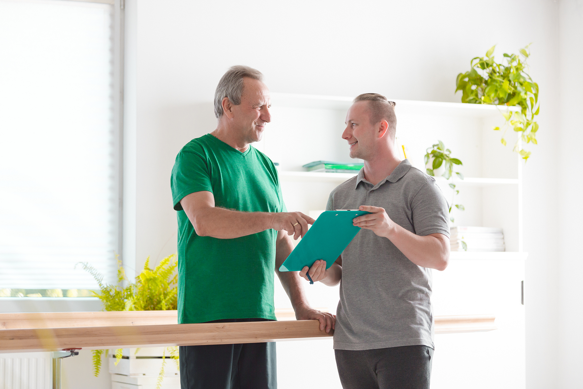 senior man discussing excercises with his physiotherapist