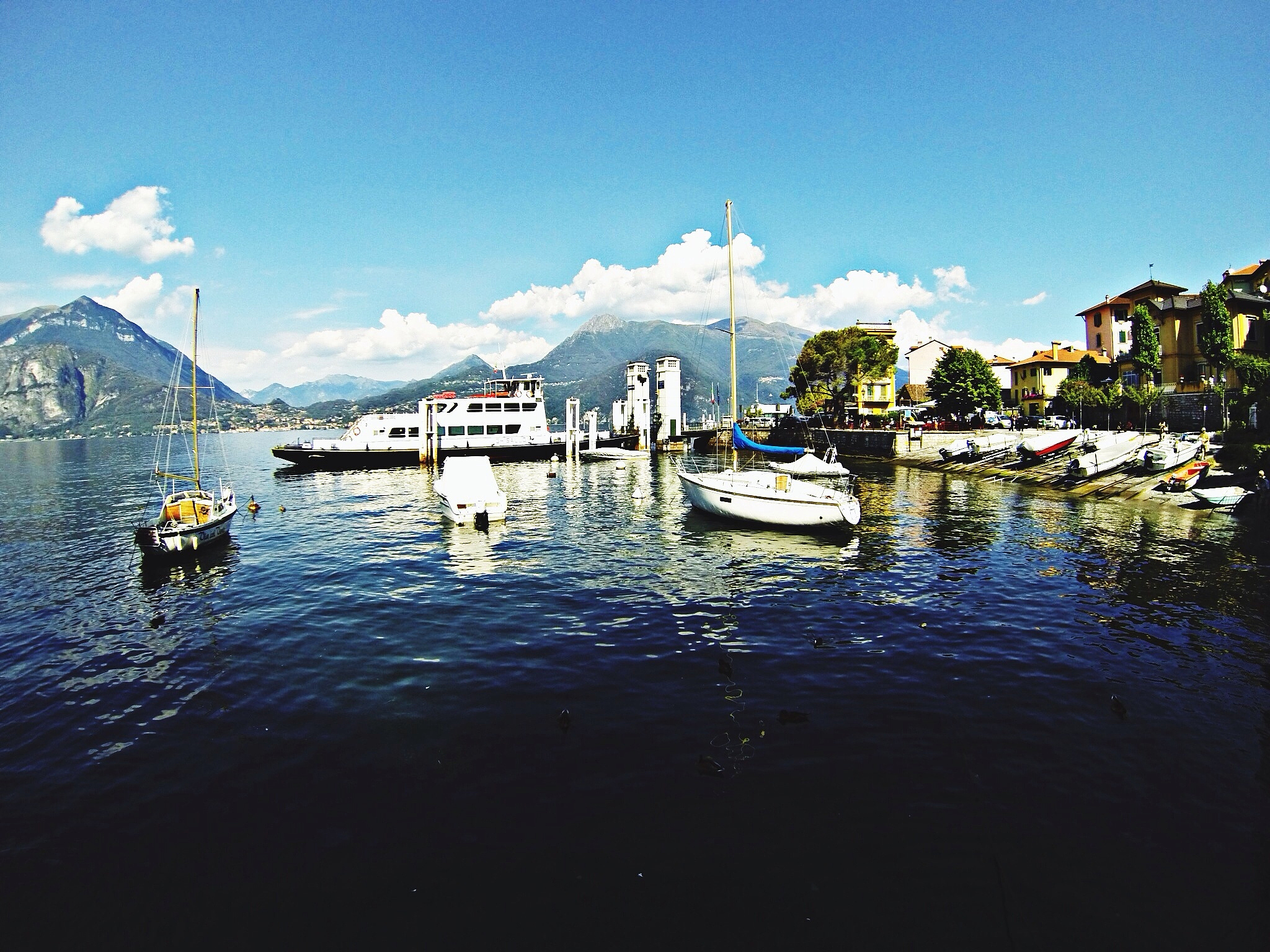scenic view of boats in lake against blue sky