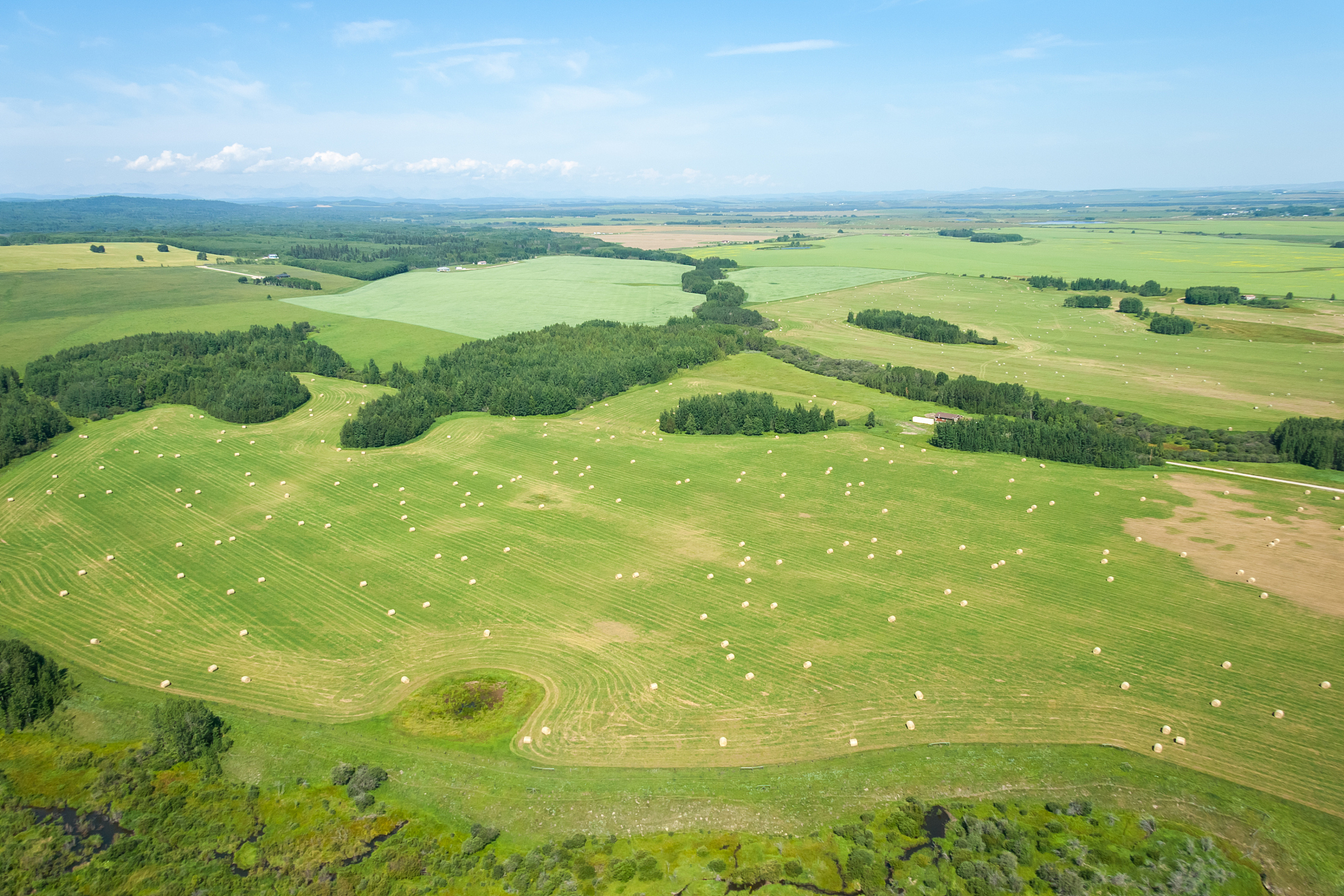aerial view of farm land and hey barrels during summer season.
