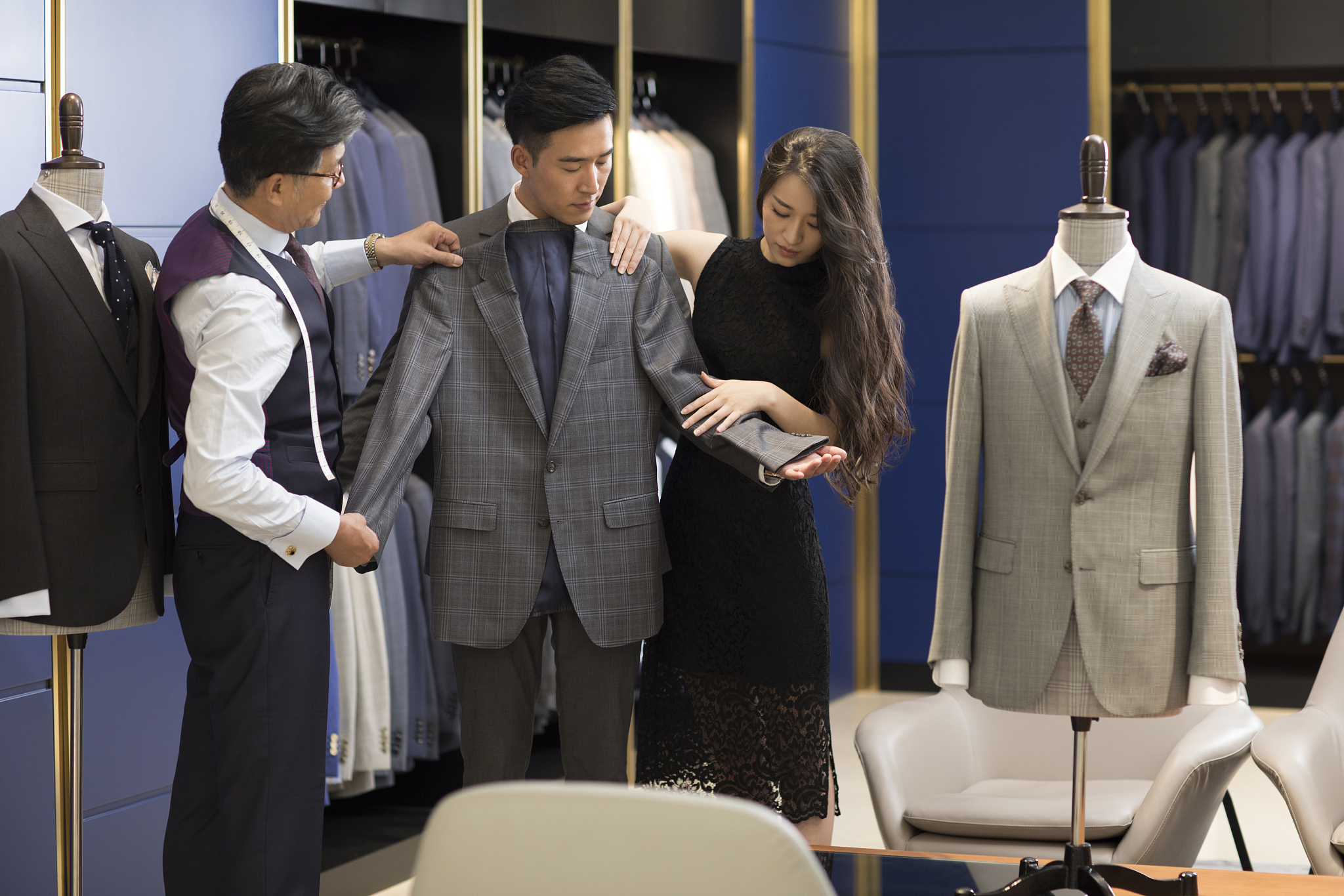 年轻情侣在服装店挑选西装