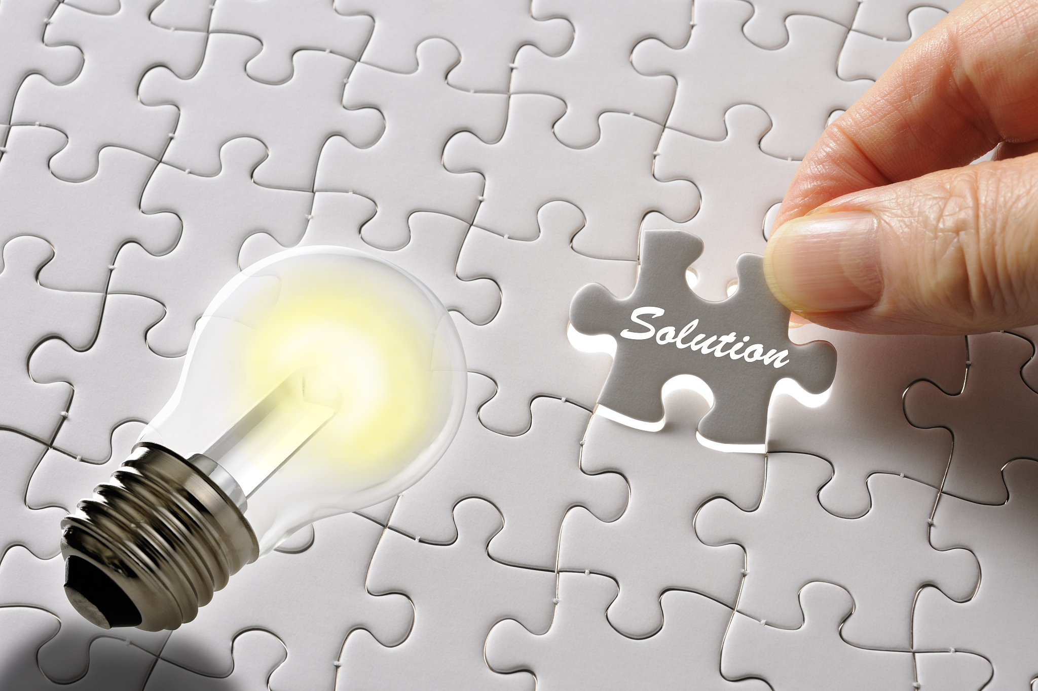 holding a last solution puzzle piece with led light bulb