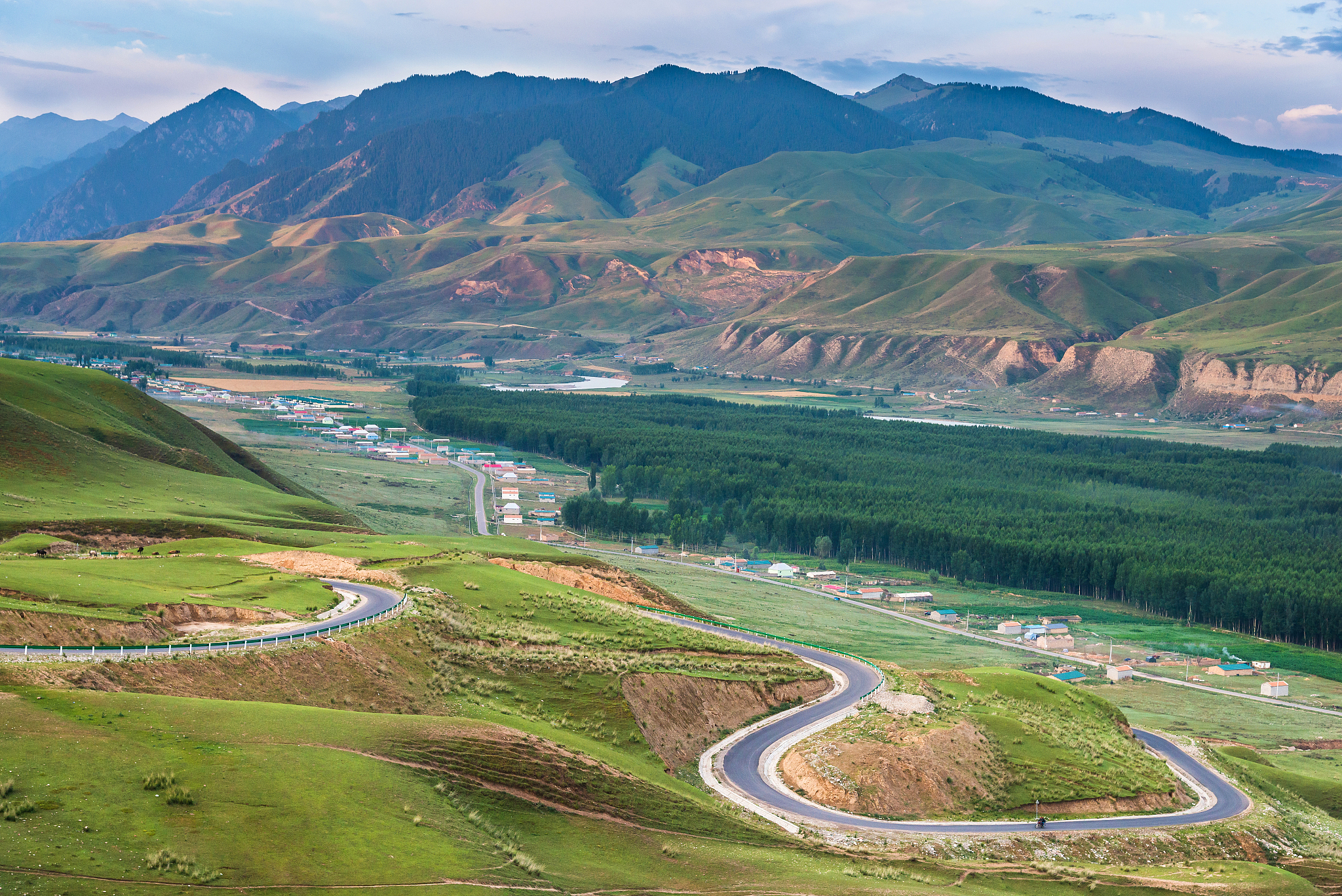 landscape of village in mountain valley with rural road winding 