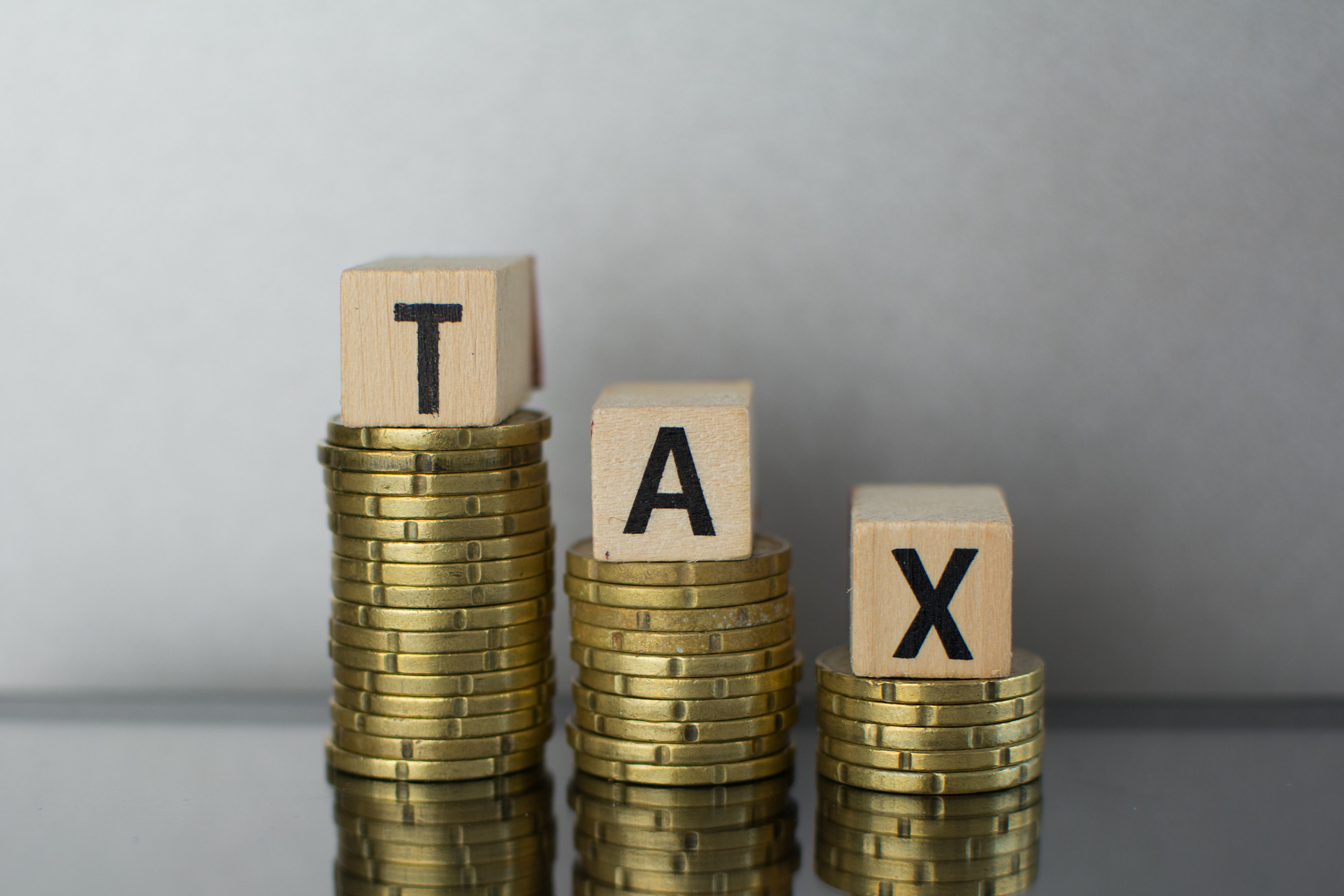 tax concept with wooden block on stacked coins