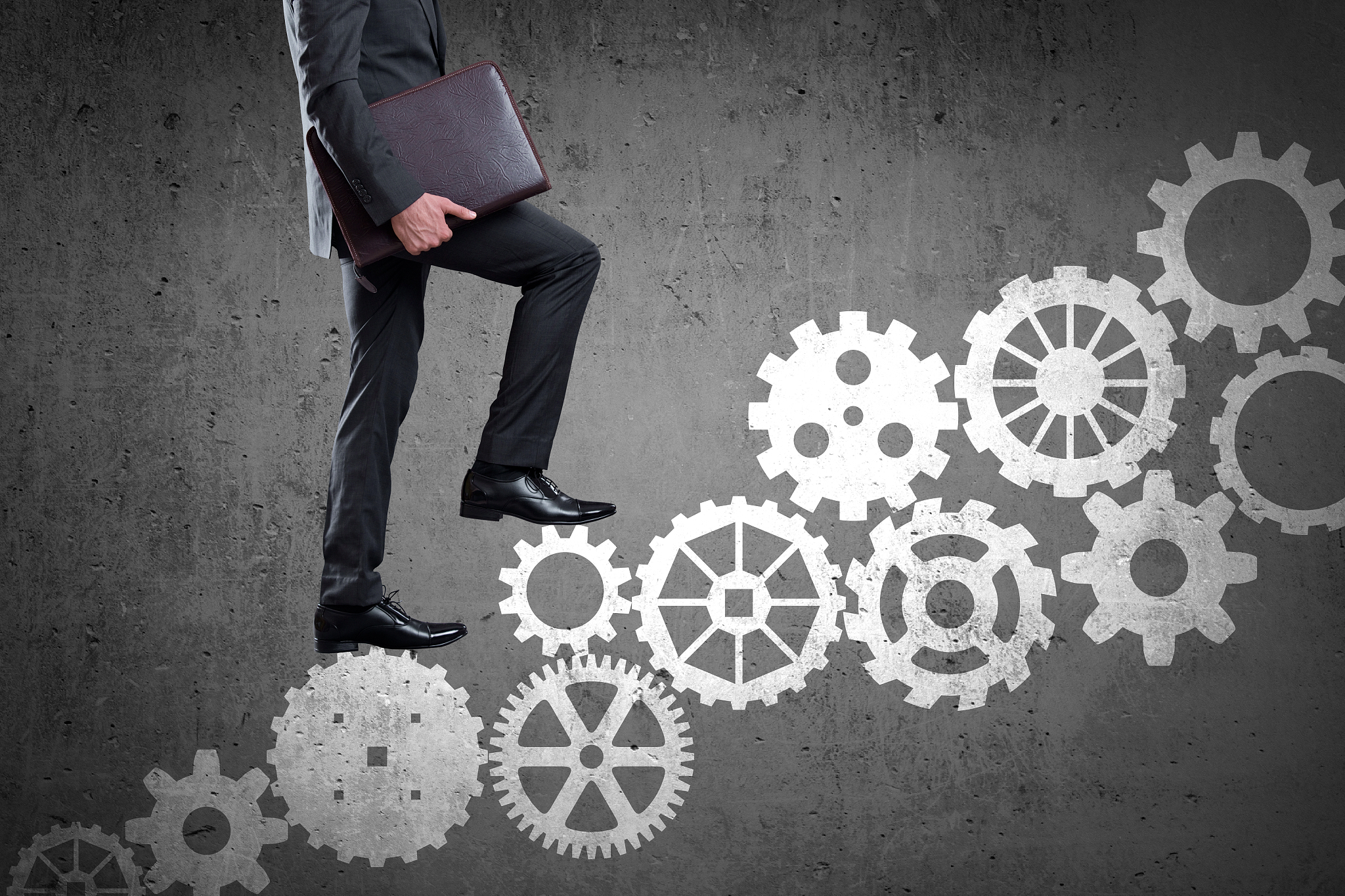 businessman walking up set of gears