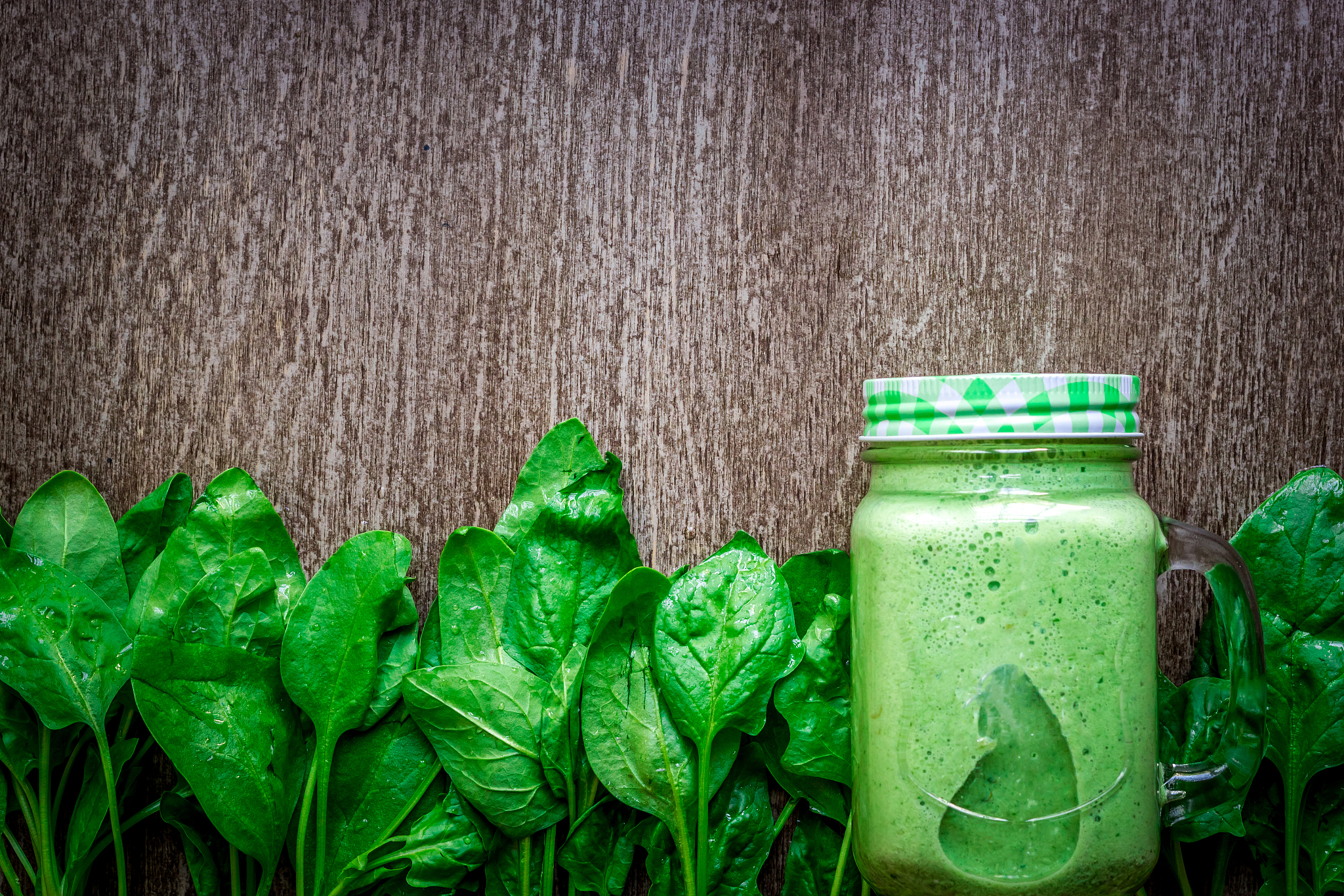 glass of spinach juice on wooden background