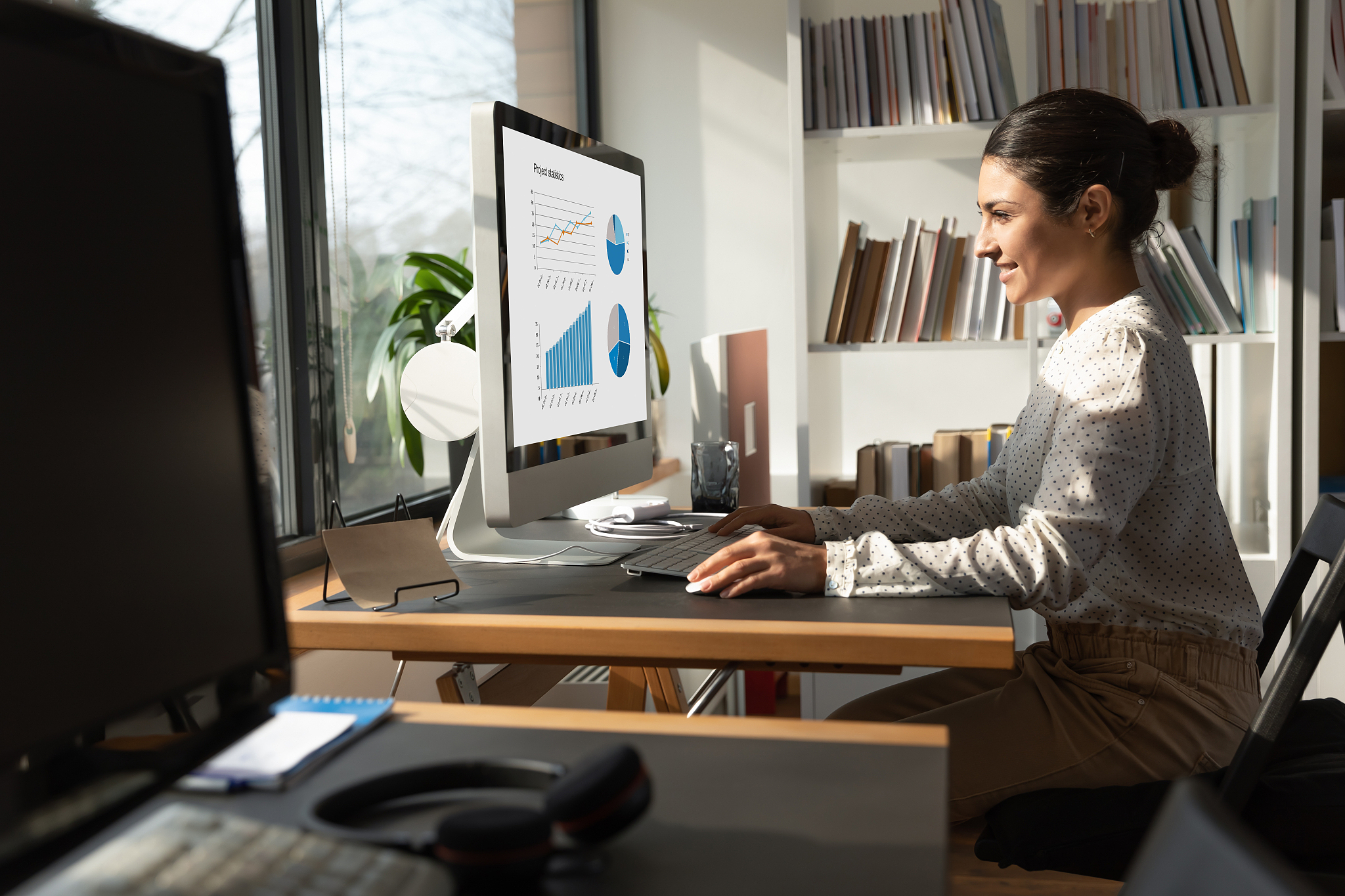 happy indian female employee working on pc in office