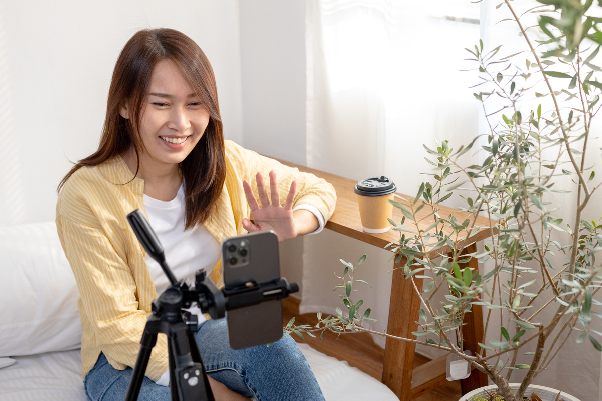 快乐的女性内容创作者用智能手机进行在线直播,涉及和