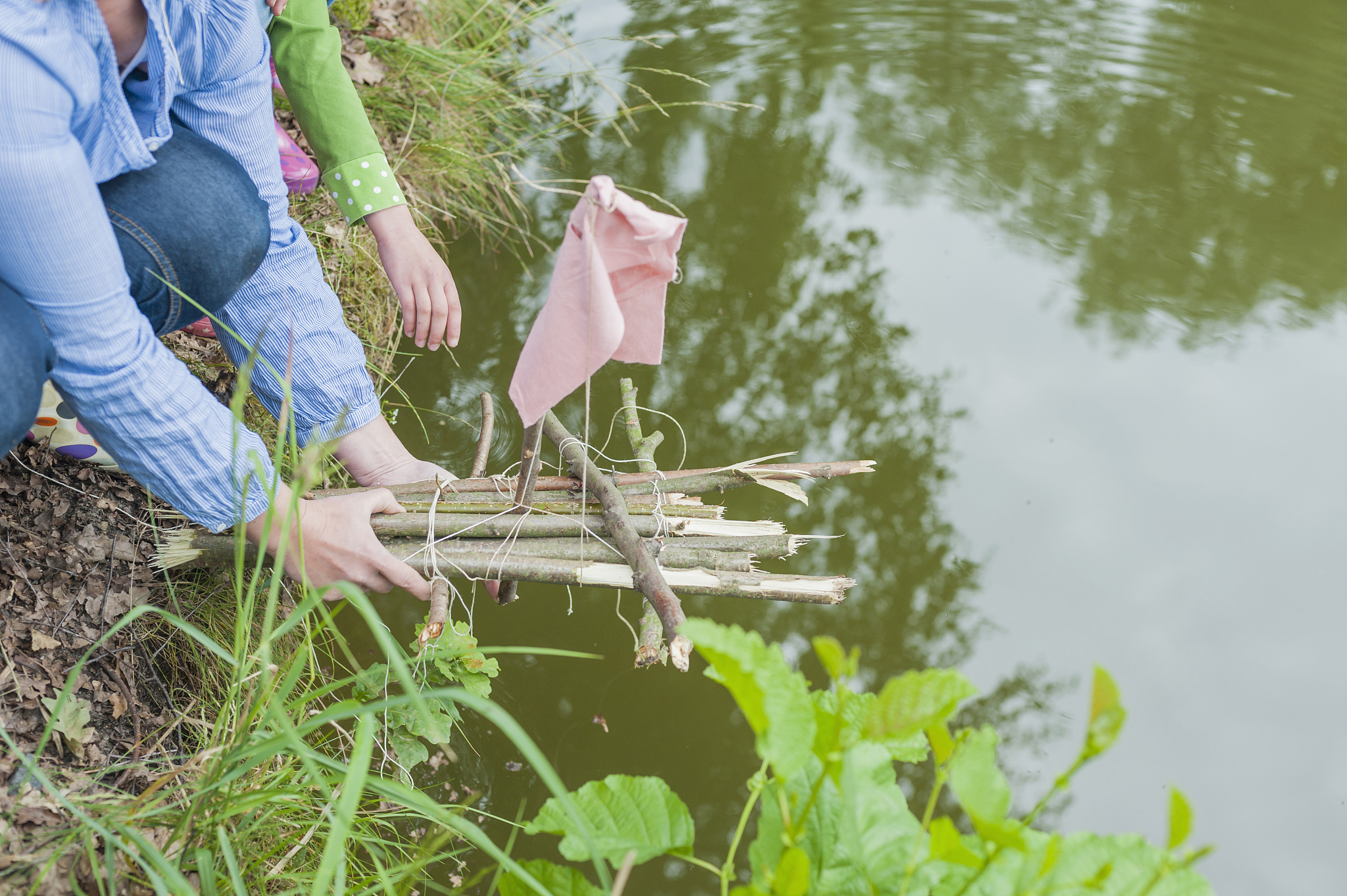 germany, woman putting toy raft in water