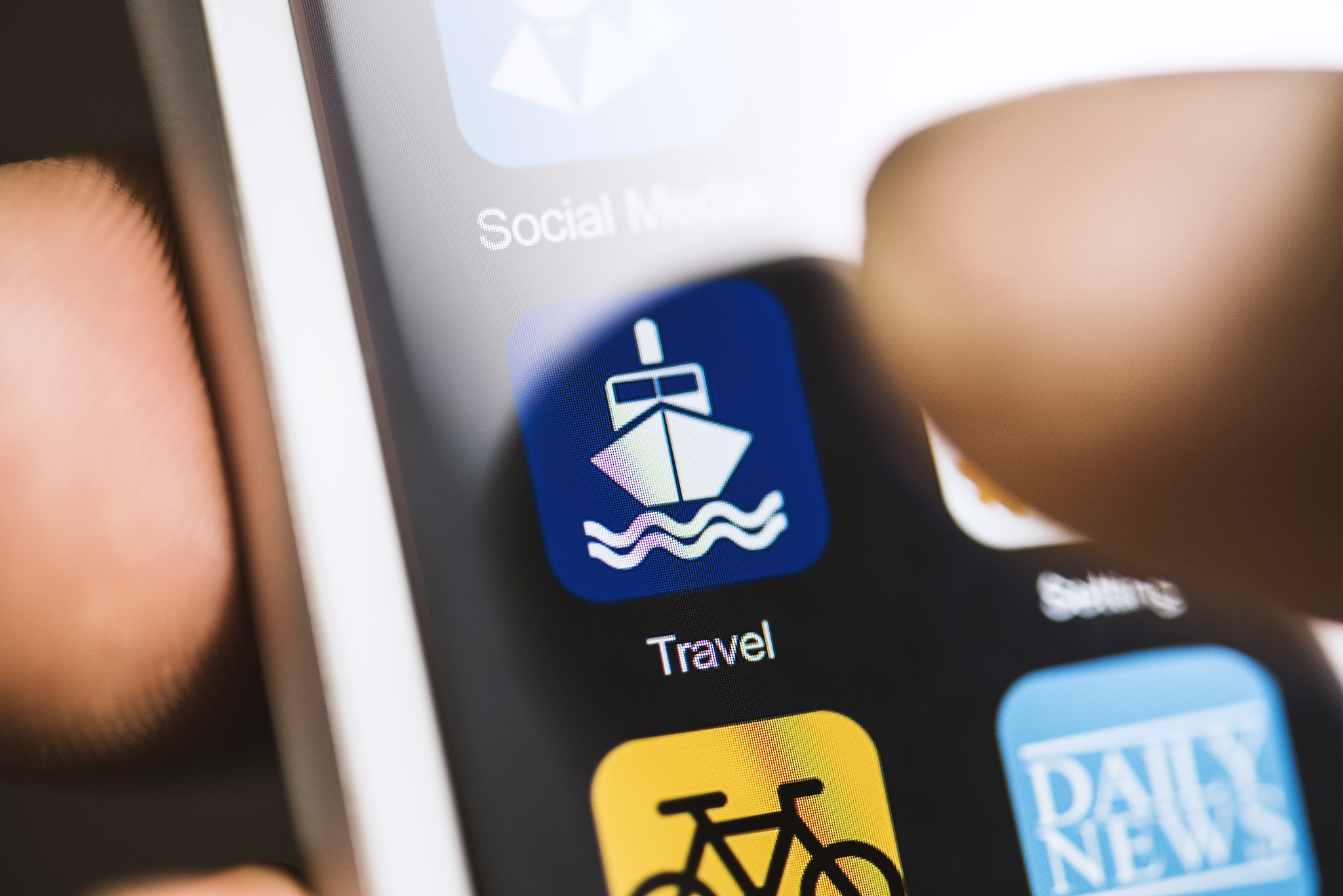 hand holding phone, touching travel app on screen