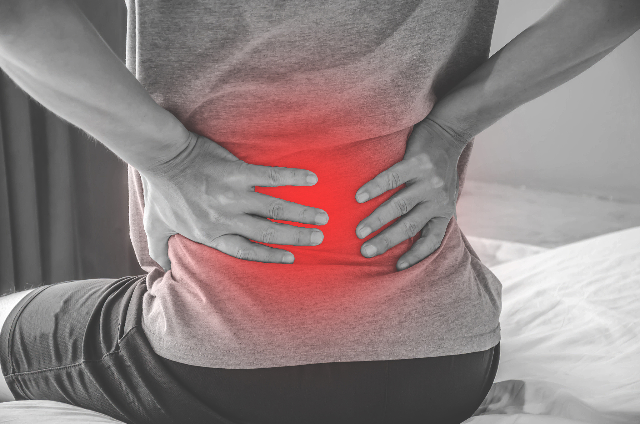 man suffering from back pain at home in the bedroom. uncomfortab