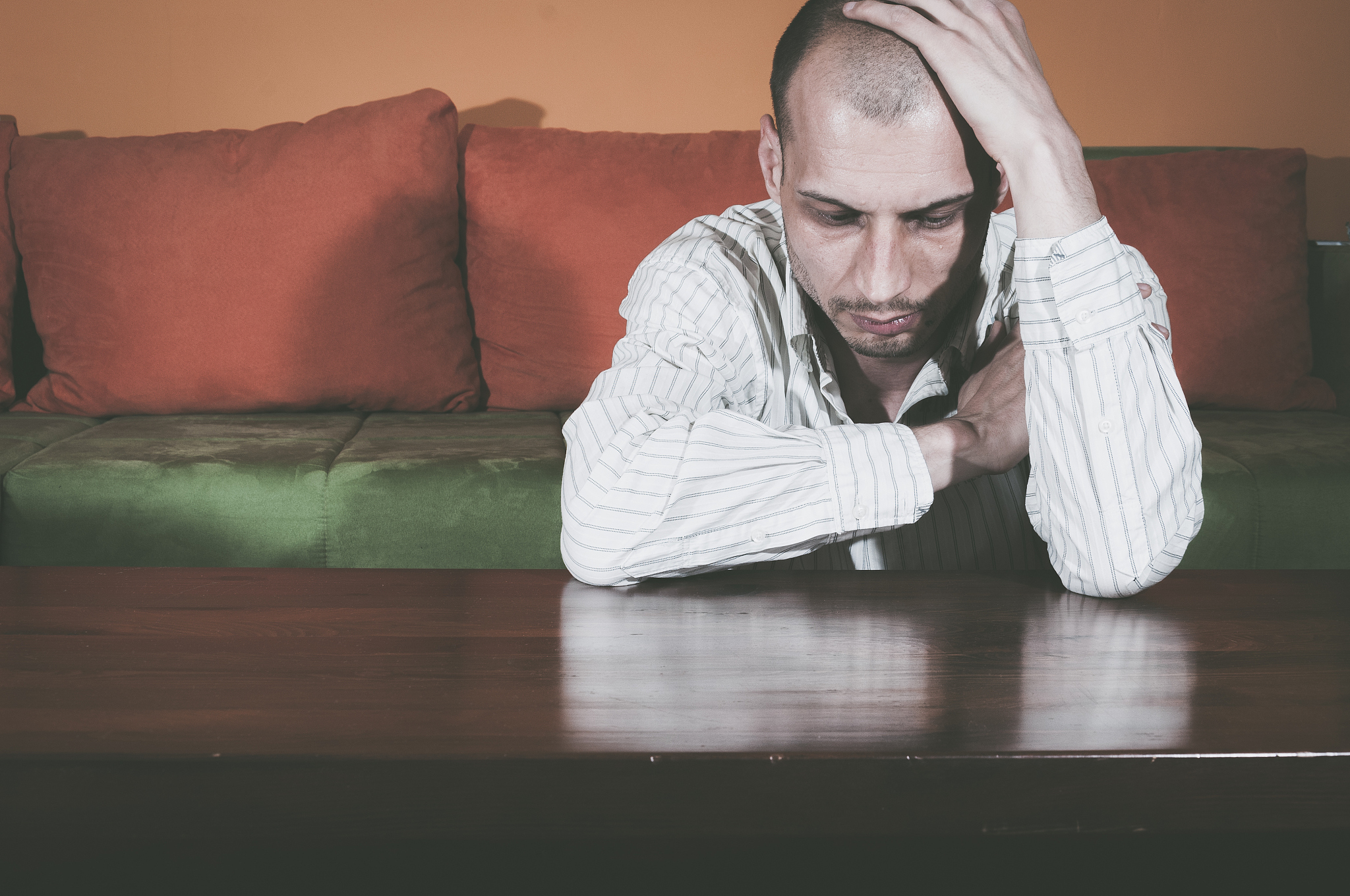 miserable young man sitting alone in his room. depression.