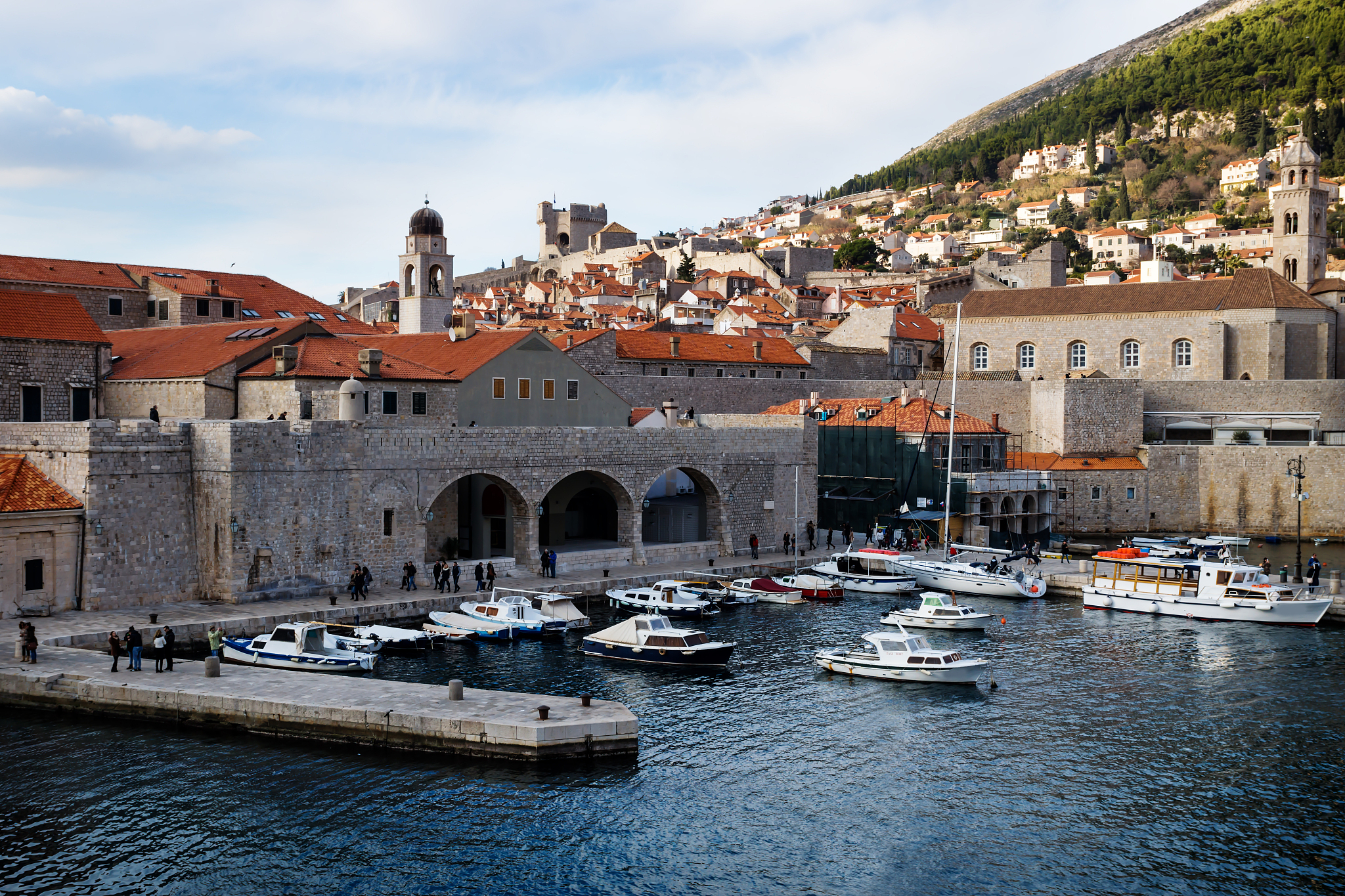 harbor of dubrovnik with boats and view on pier and mountain in 