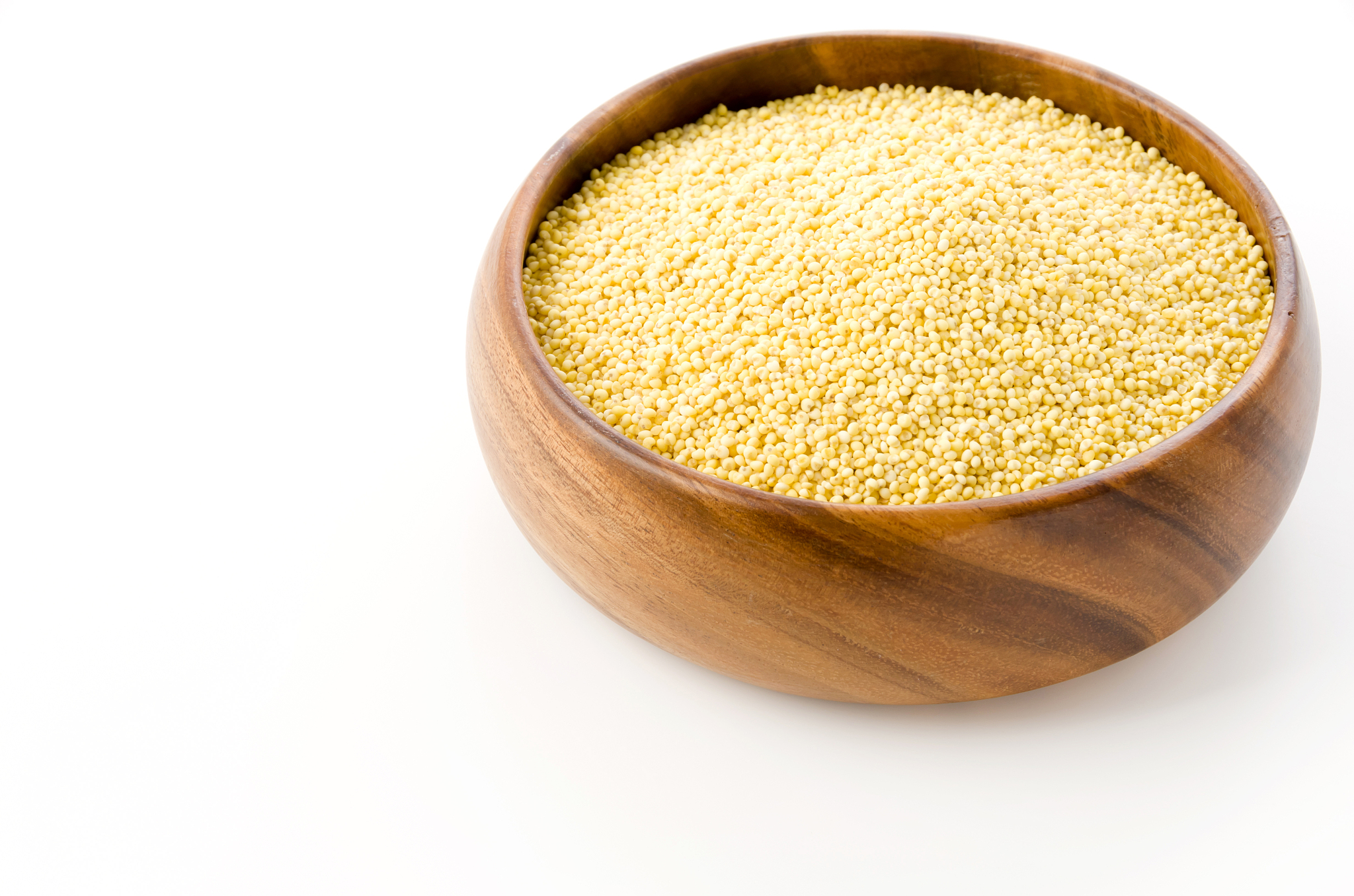 glutinous millet in round wooden bowl on white background