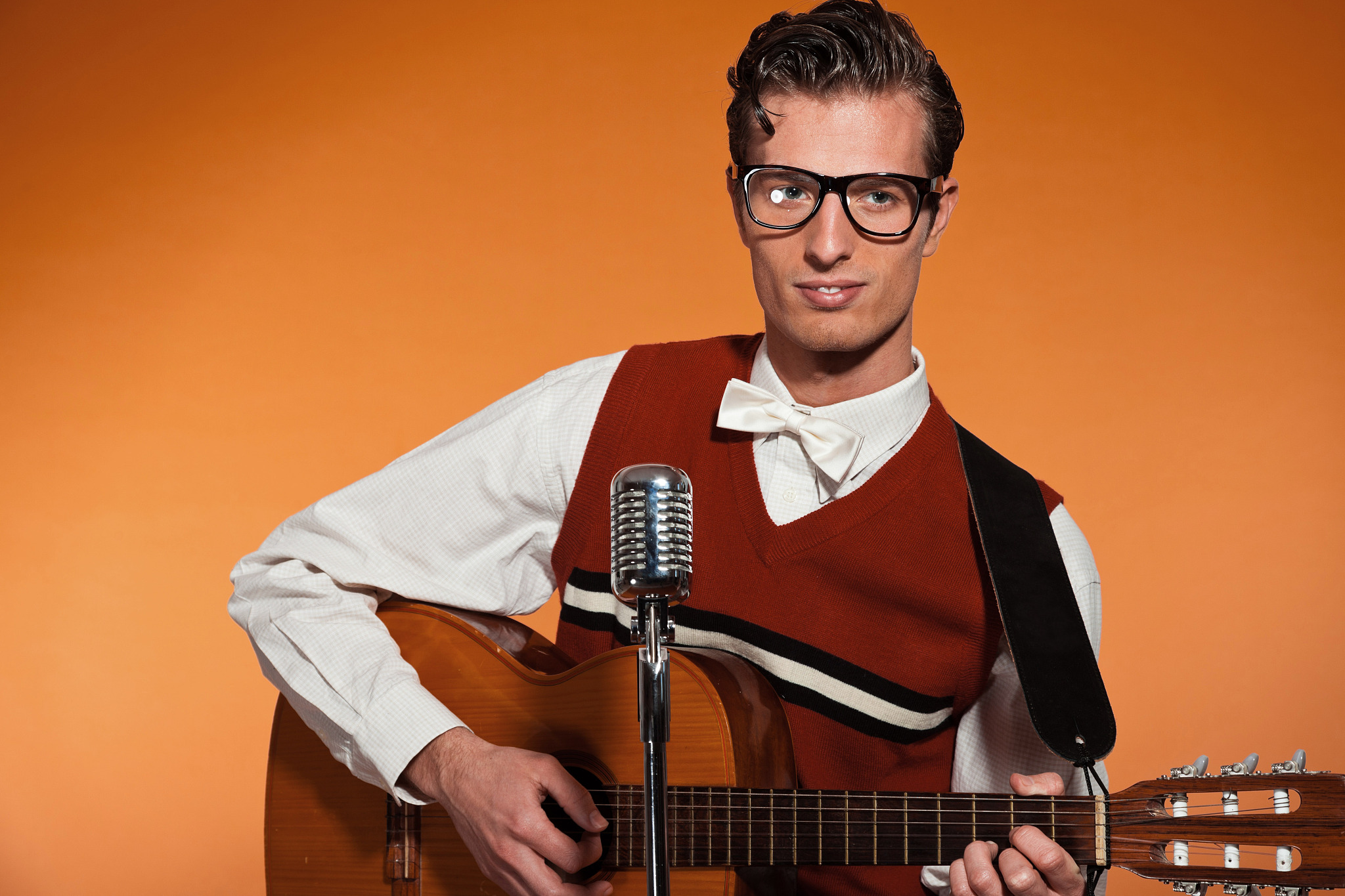 retro fifties musician with glasses playing acoustic guitar.