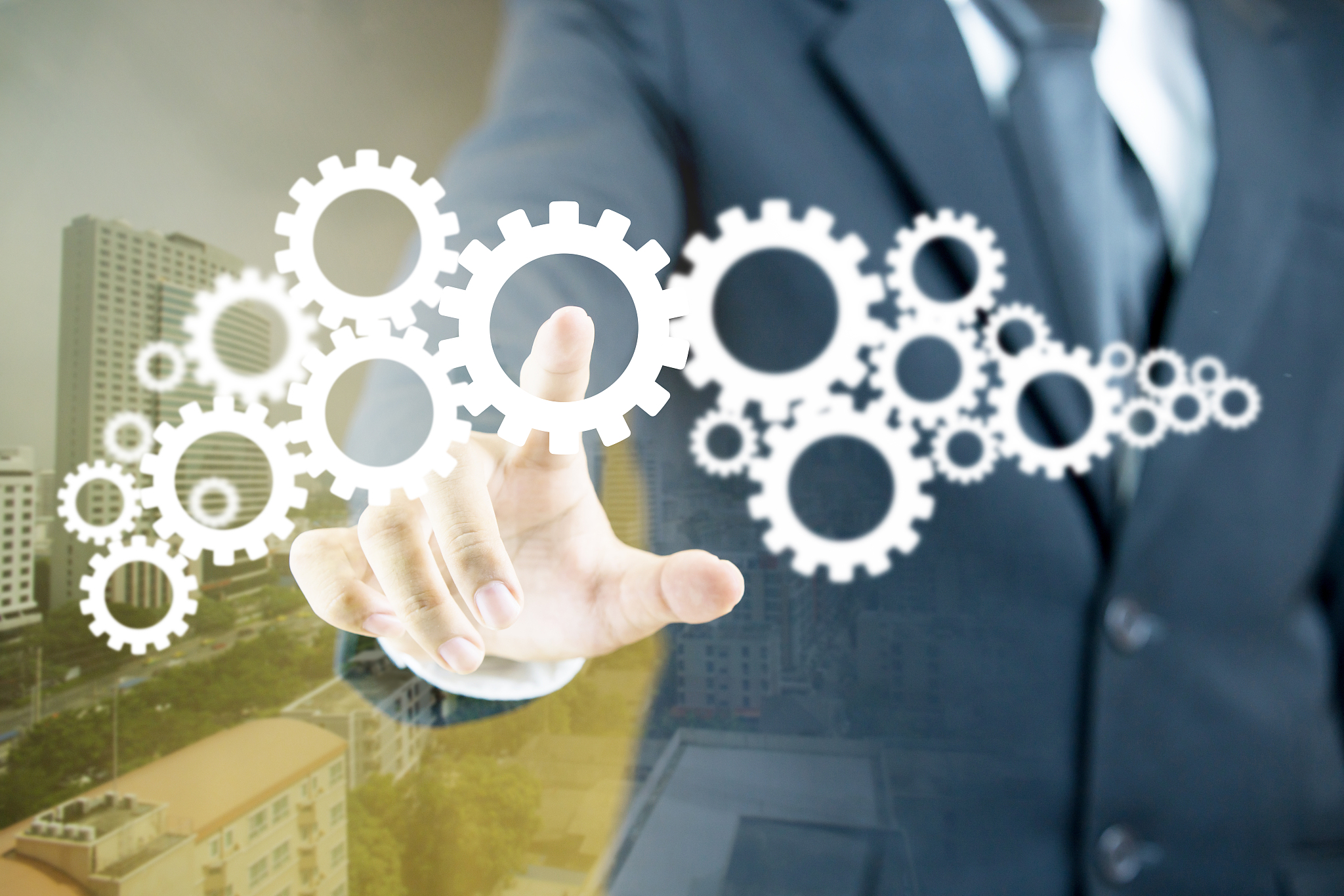 double exposure of businessman touching gears and buildings