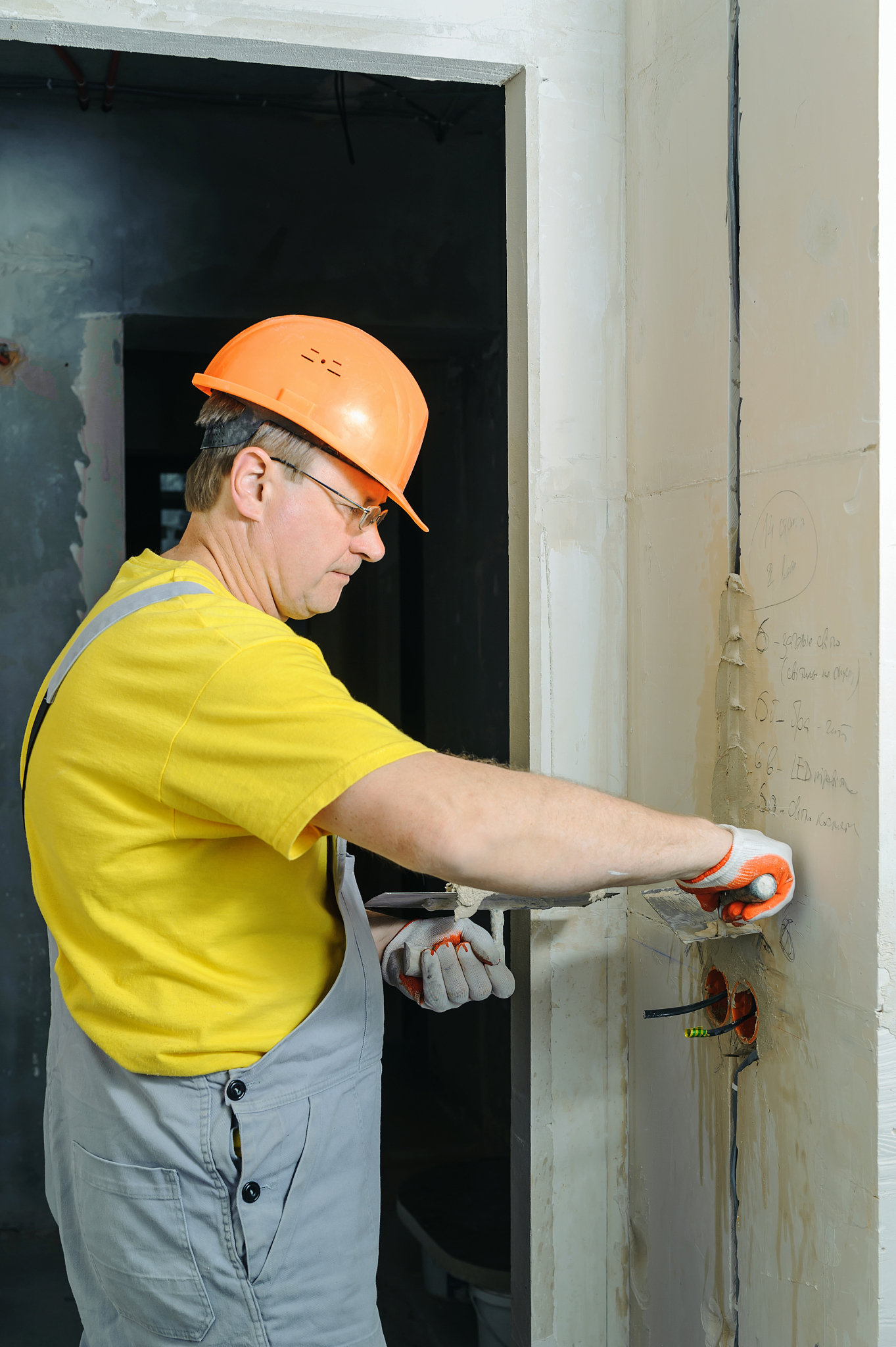 the worker is plastering the electric corrugated tubes in the wa