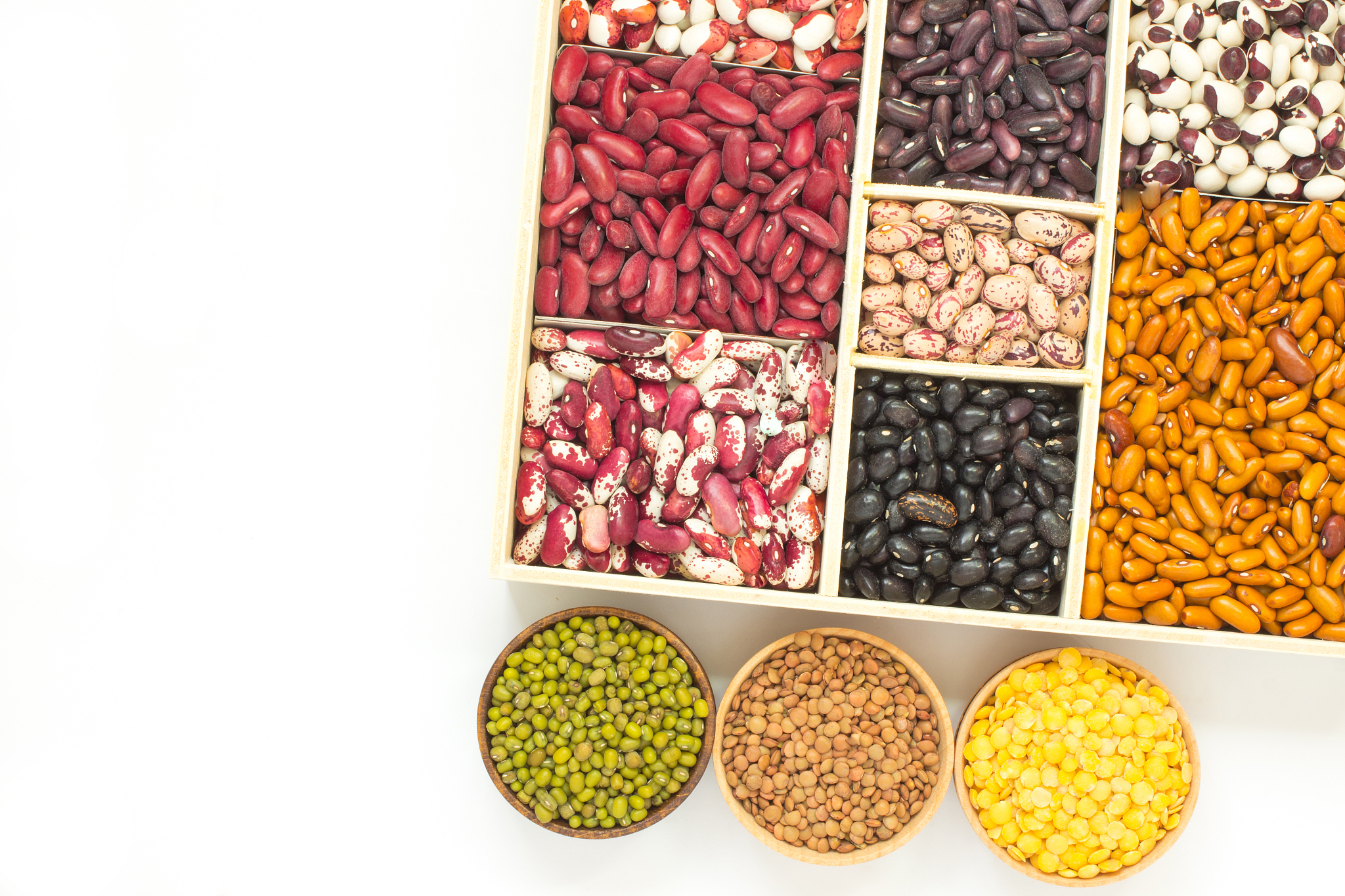 different varieties of beans in a wooden box. lentils different