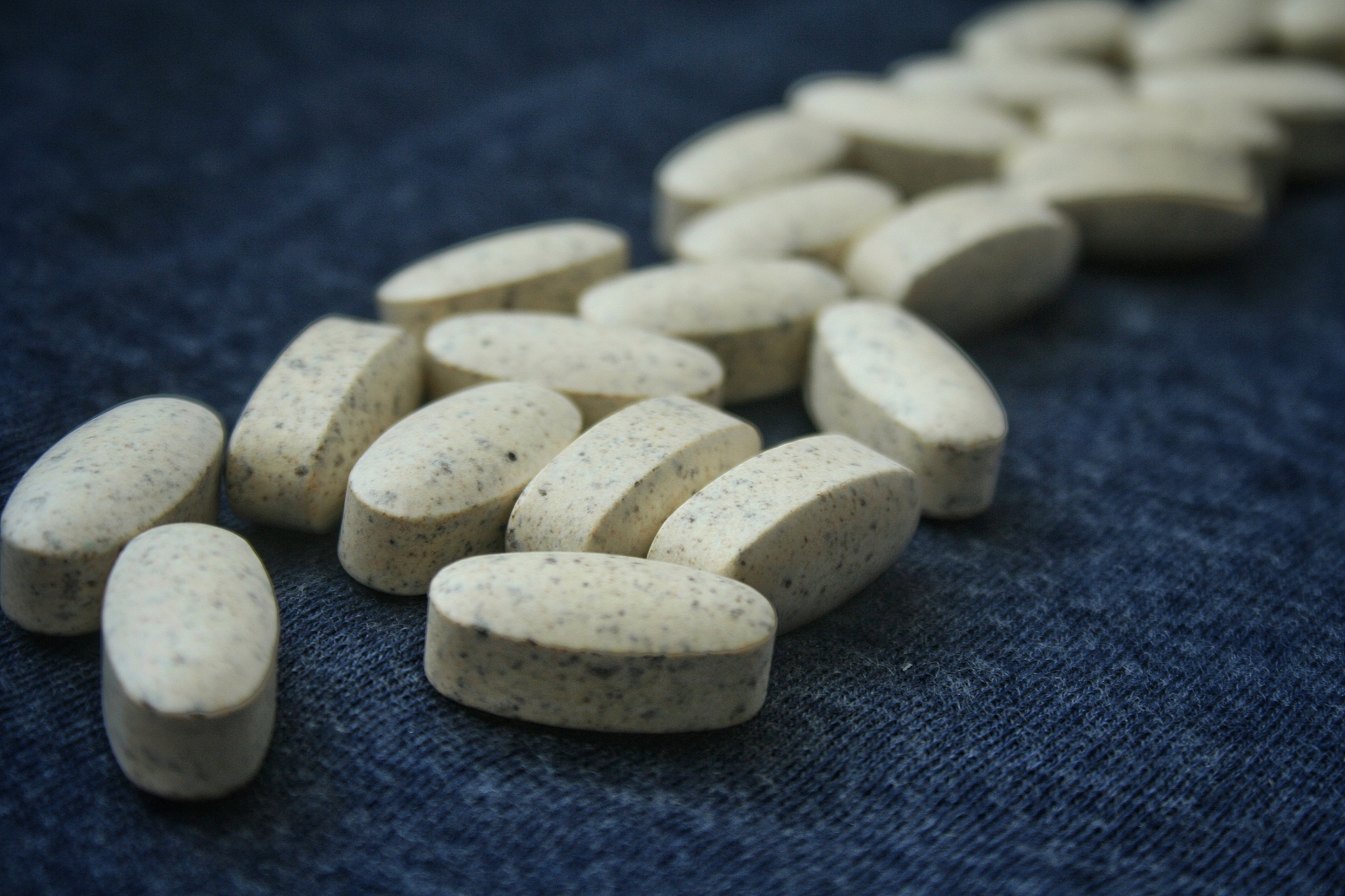 white medical pills on blue background.