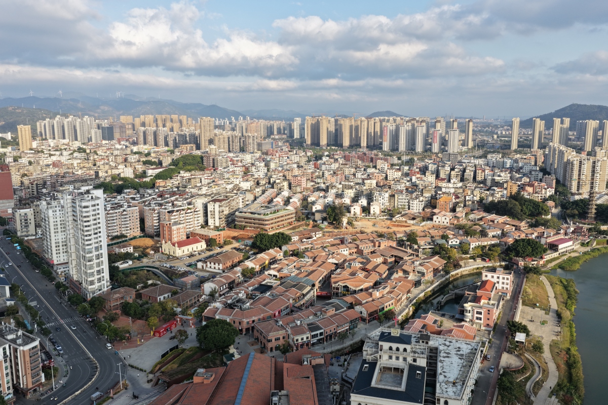 高密度城市区域的空中视角,有现代高楼和河流附近的低