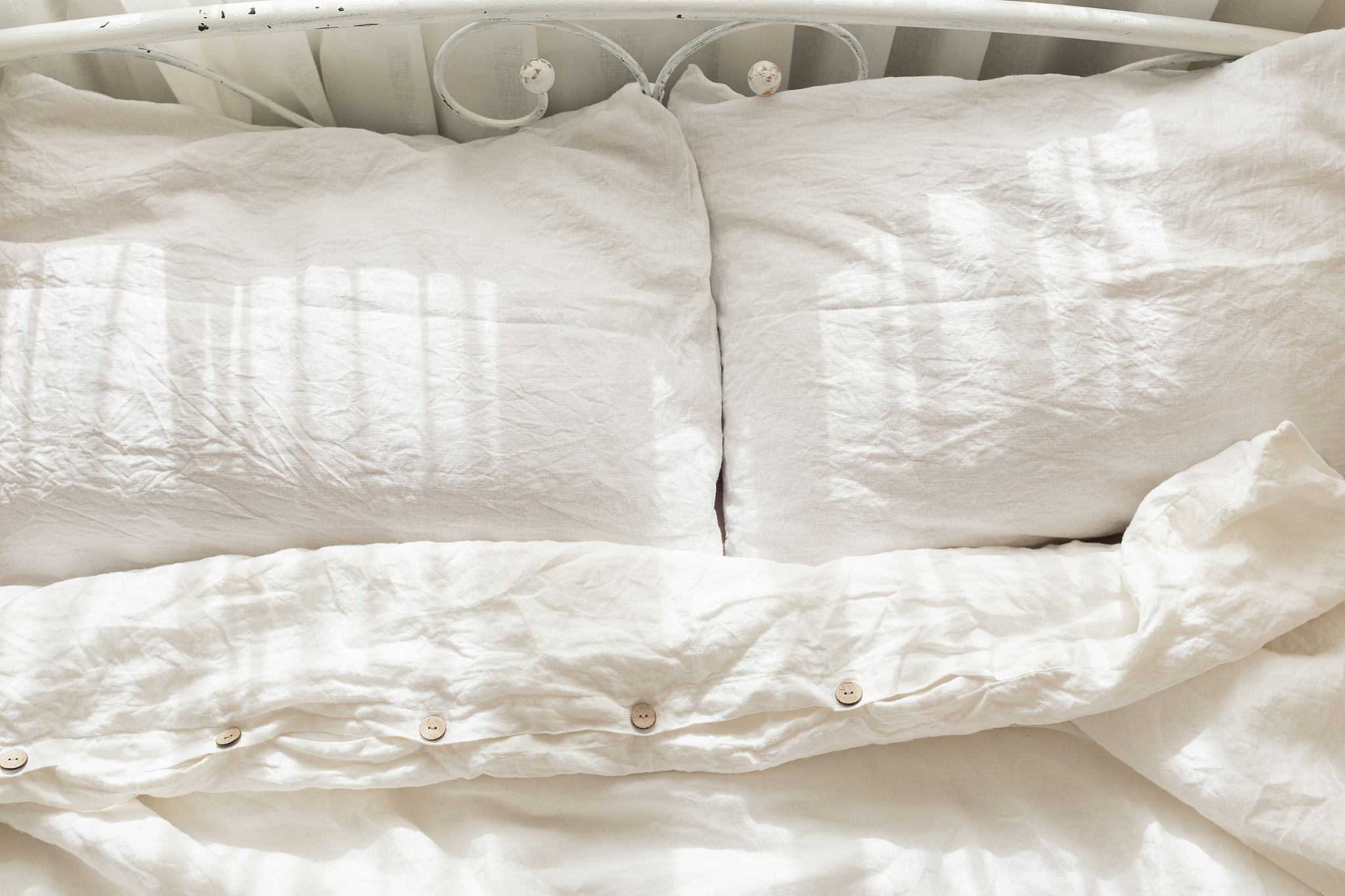 beautiful morning light in bedroom. pastel color white bedding. 